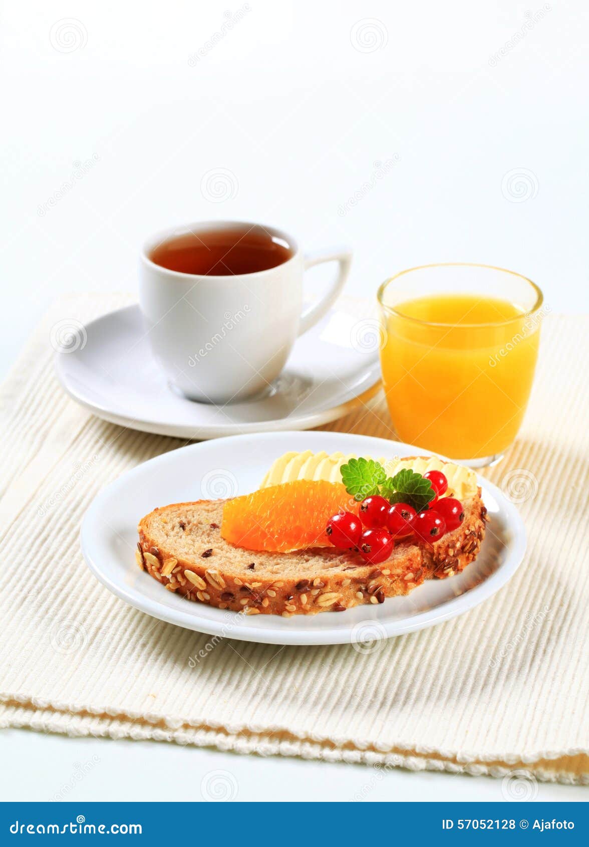 Bröd med smör, kopp te och orange fruktsaft. Bröd med smör och frukt, kopp te och orange fruktsaft