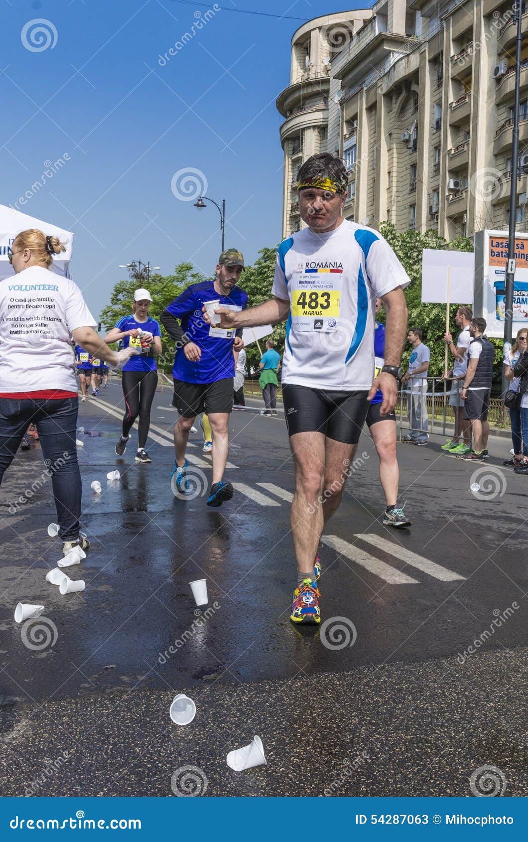 Marathon Runner Picking Up Water at Service Point Editorial Stock Photo