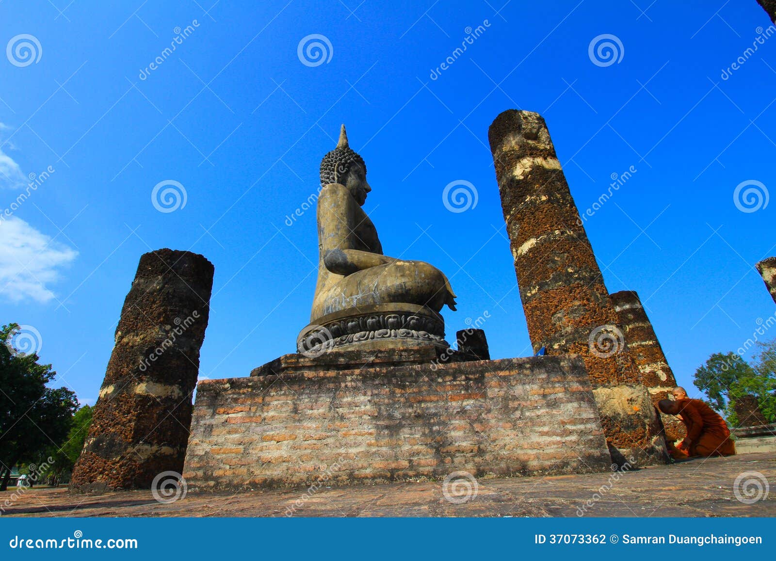 Viejo Buda se sienta entre columna