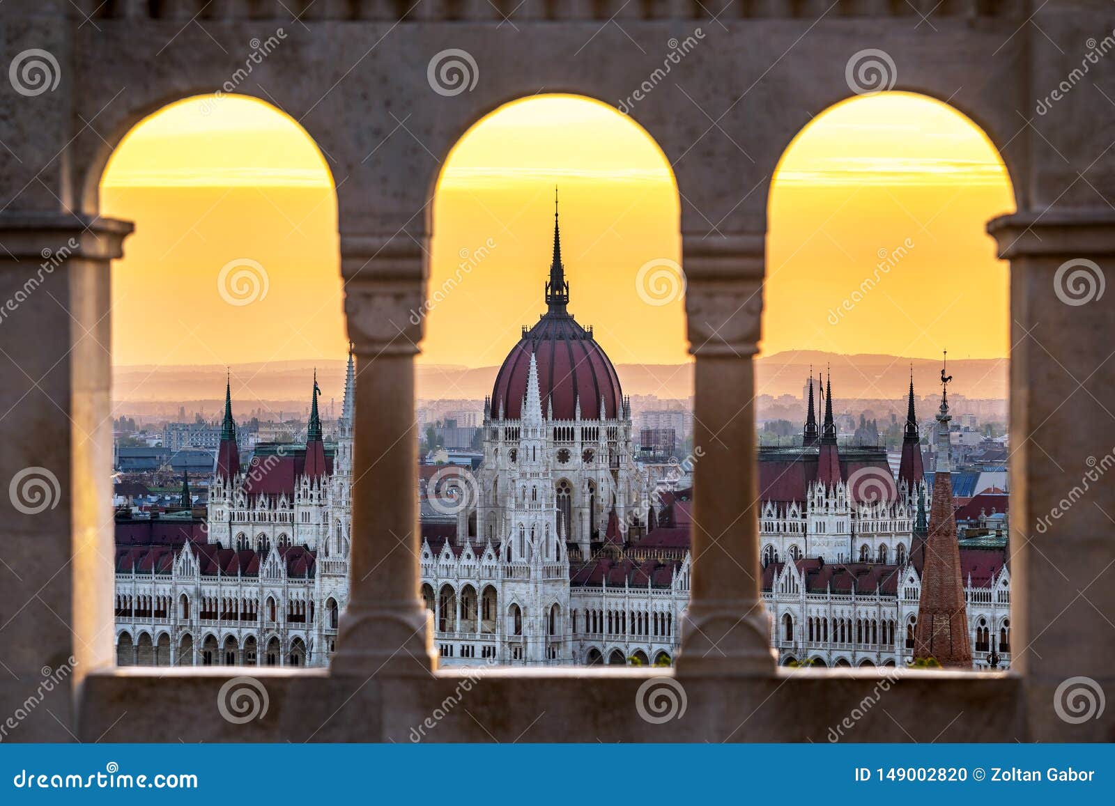 budapest, hungary - the hungarian parliament building at sunrise looking through old stone windows