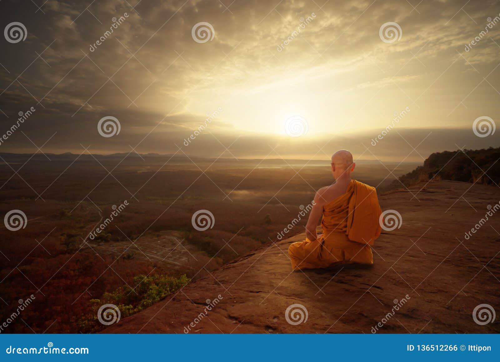 buddhist monk in meditation at beautiful sunset or sunrise background