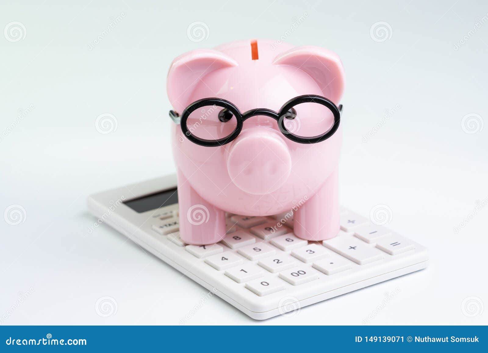 budget, cost or investment calculation and financial activity concept, pink piggy bank wearing glasses on white calculator on