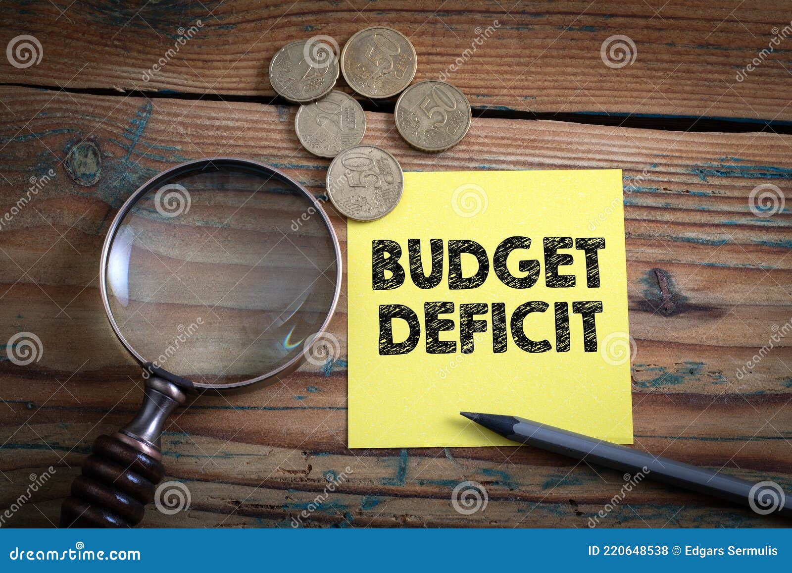 budget deficit. euro cash and magnifying glass on a wooden background