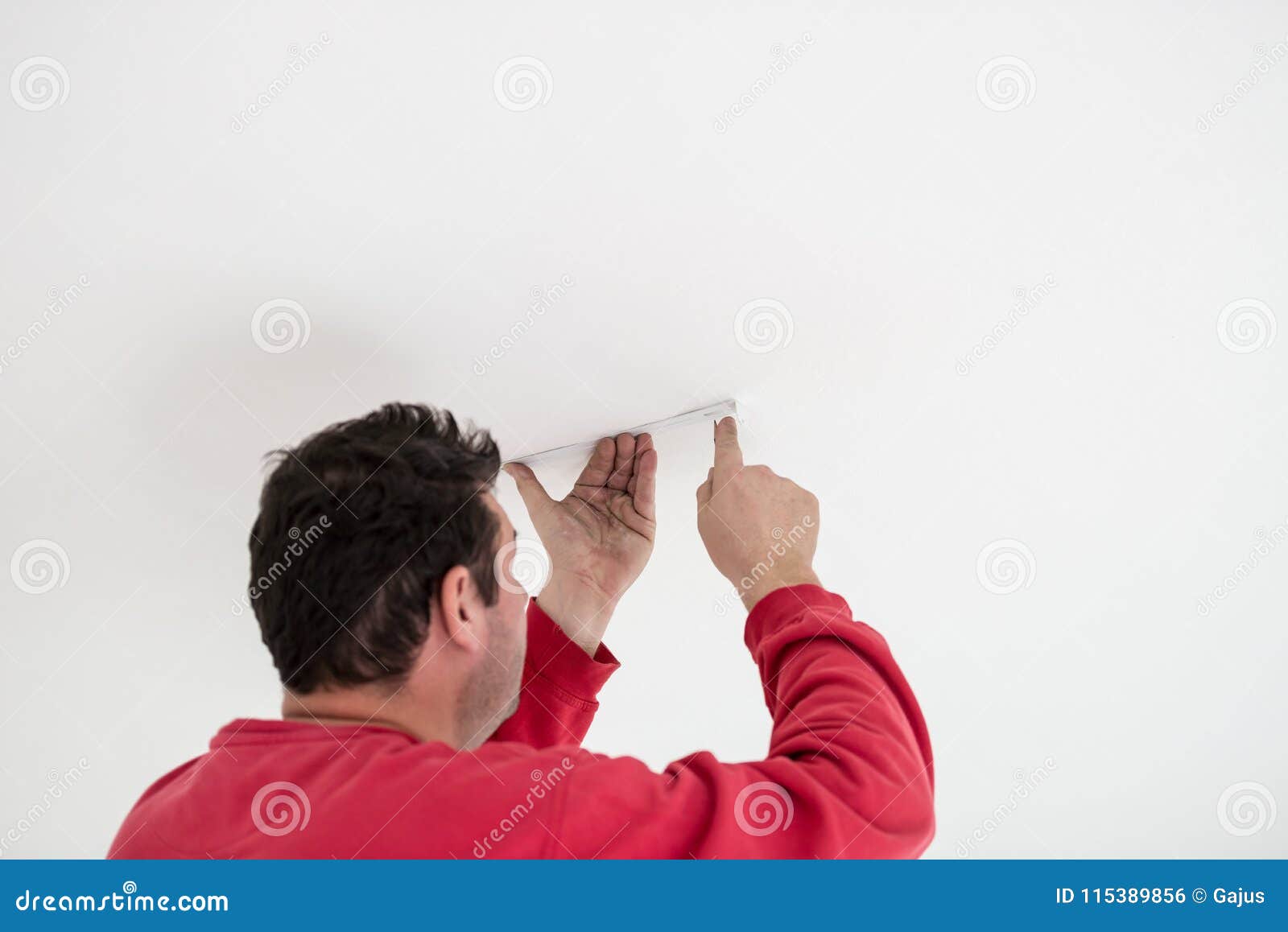 Builder Attaching A Cable Or Conduit To A Ceiling Stock