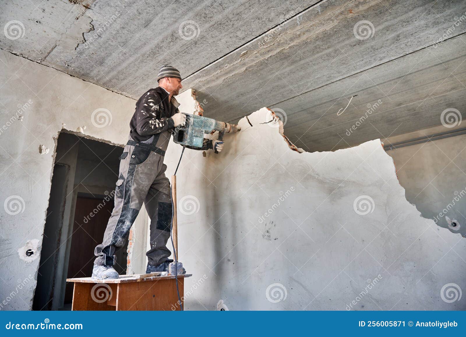 builder destroying inner septum using perforator in apartment.