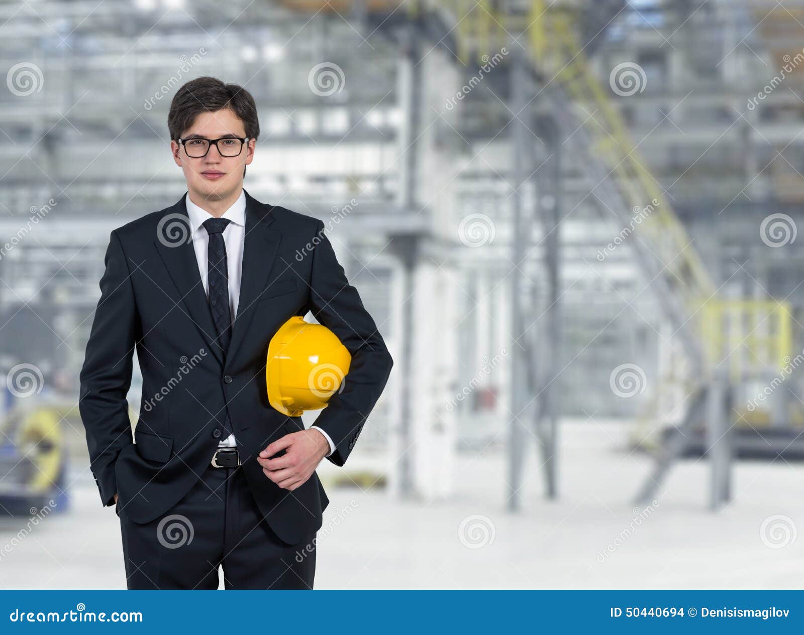 Builder on factory. Builder with yellow helmet standing on factory