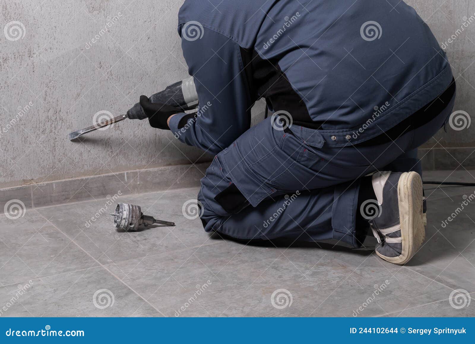 A Builder with a Form Works with a Hammer Drill. the Concept of Crushing a Concrete Wall for