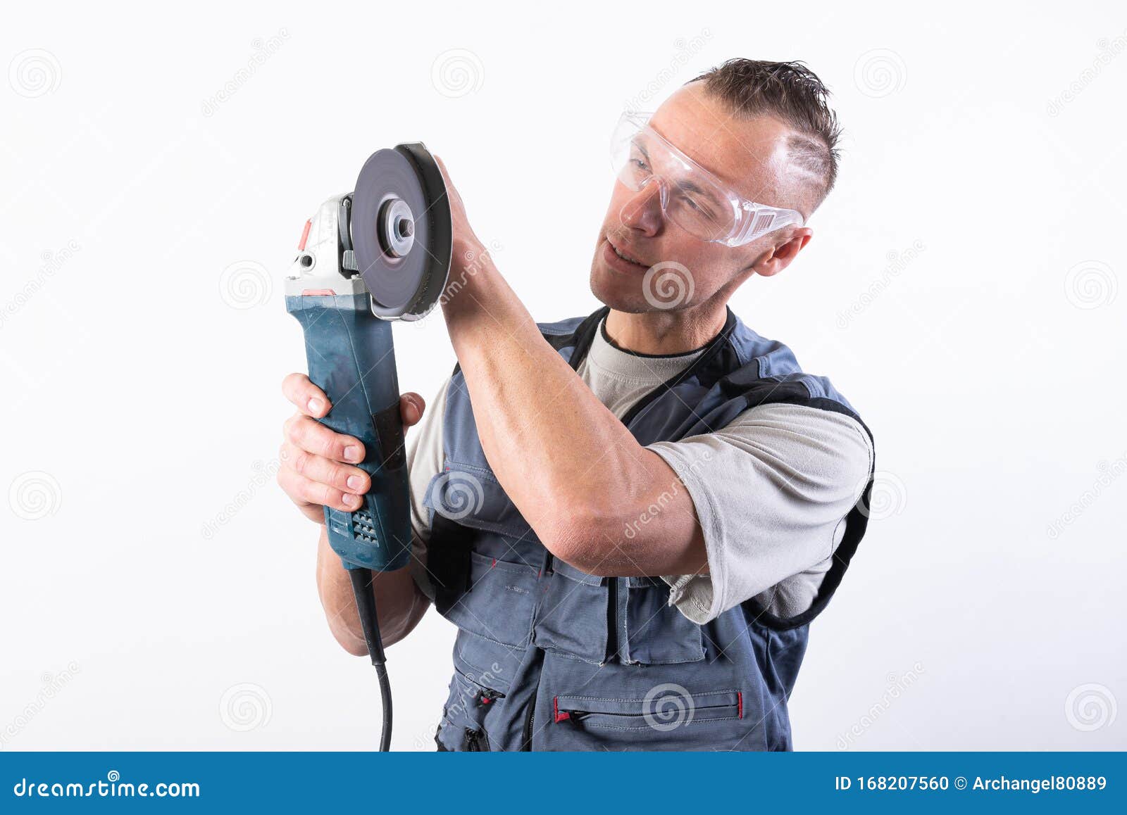 The Builder in Goggles, with an Angle Grinder in His Hands Stock Photo