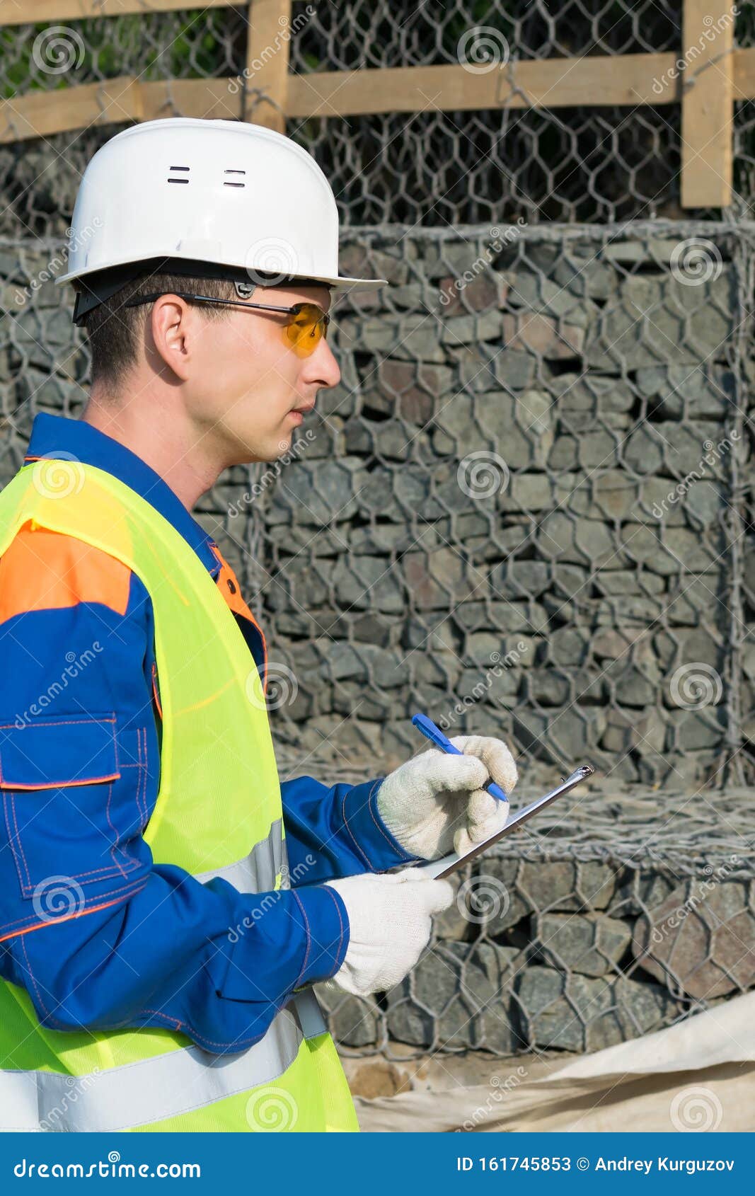 a builder in a helmet records violations in the protocol during the commissioning of the object