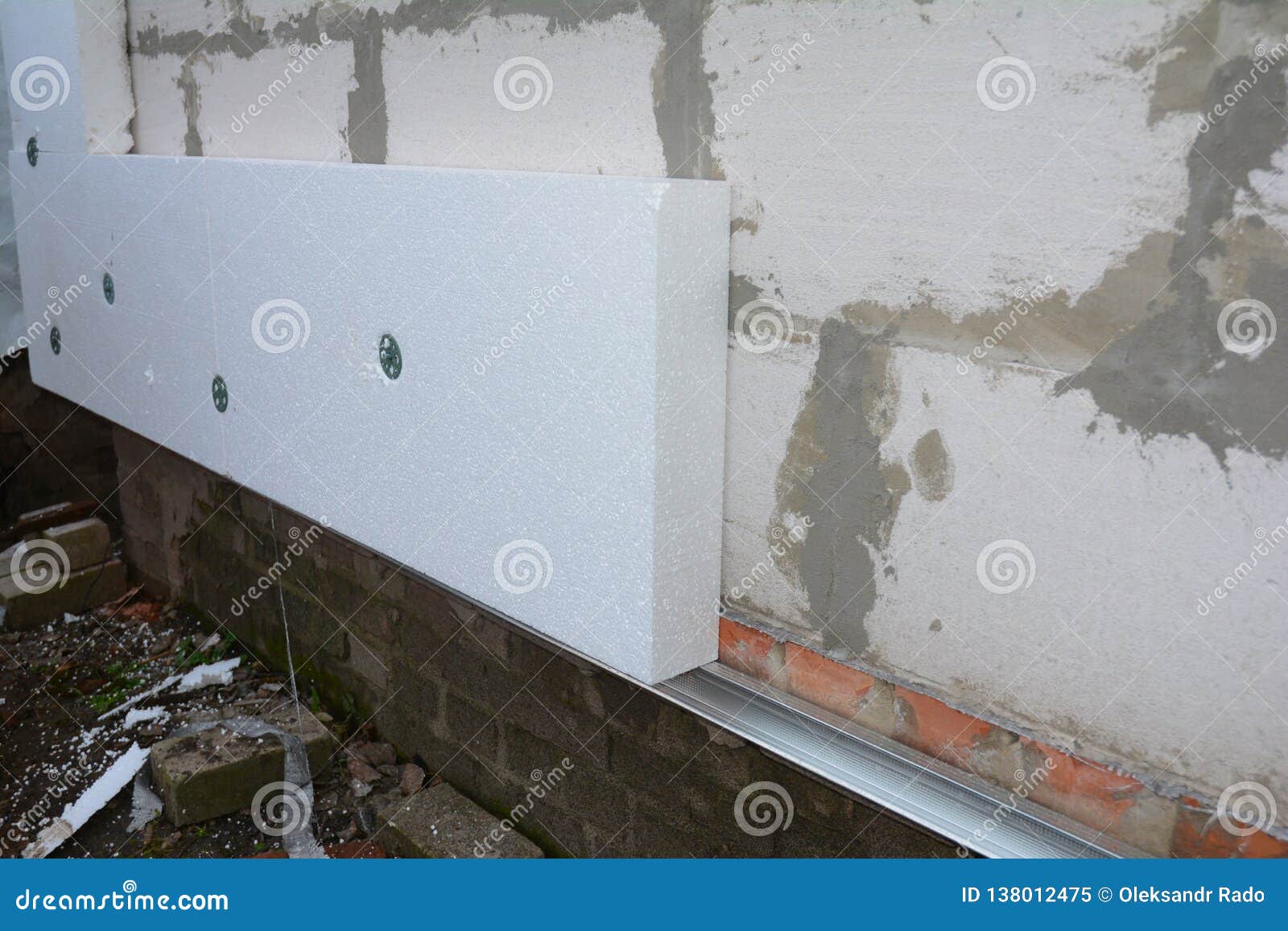 Builder Installing Anchors in House Wall for Rigid Insulation Foam