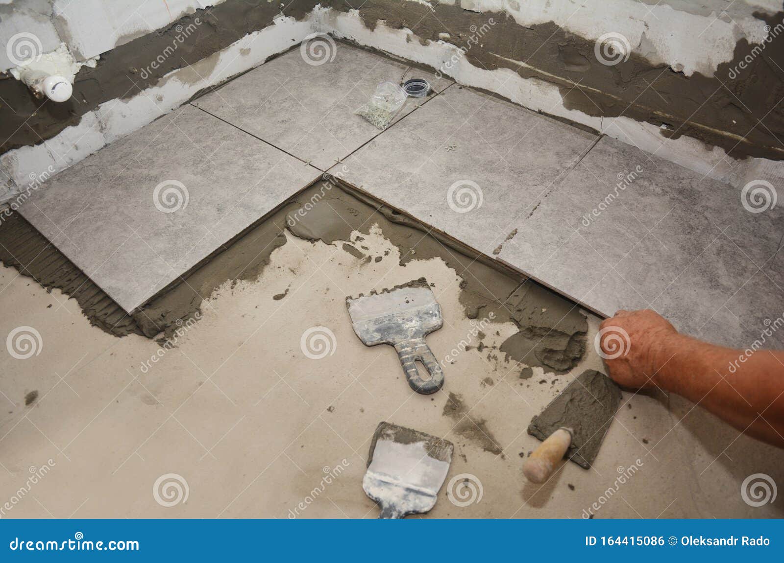Builder Installing Ceramic Tile on the Floor, Bathroom Flooring. Floor
