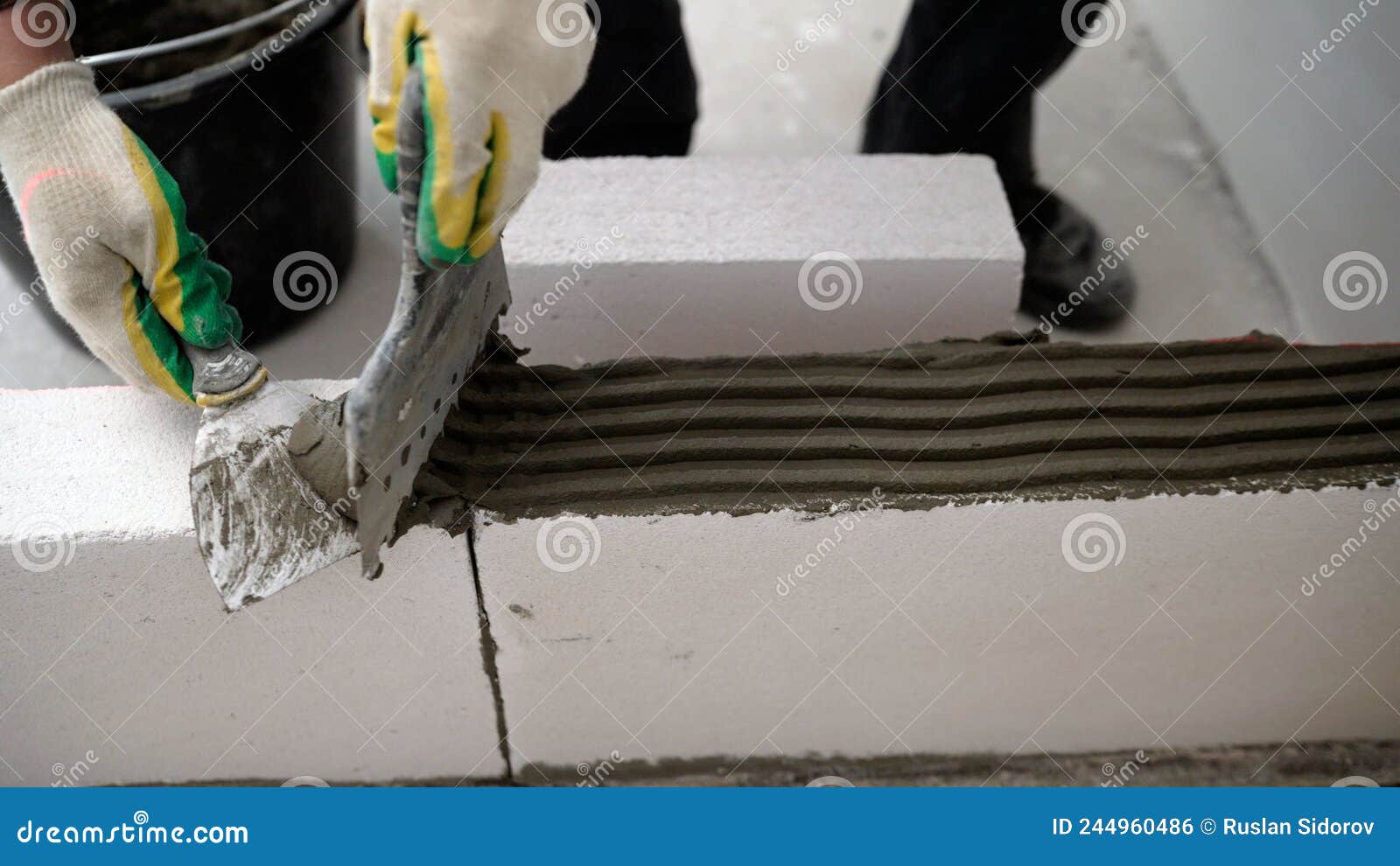 builder-mason working with aerated concrete blocks. building walls, placing bricks on a construction site, engineering