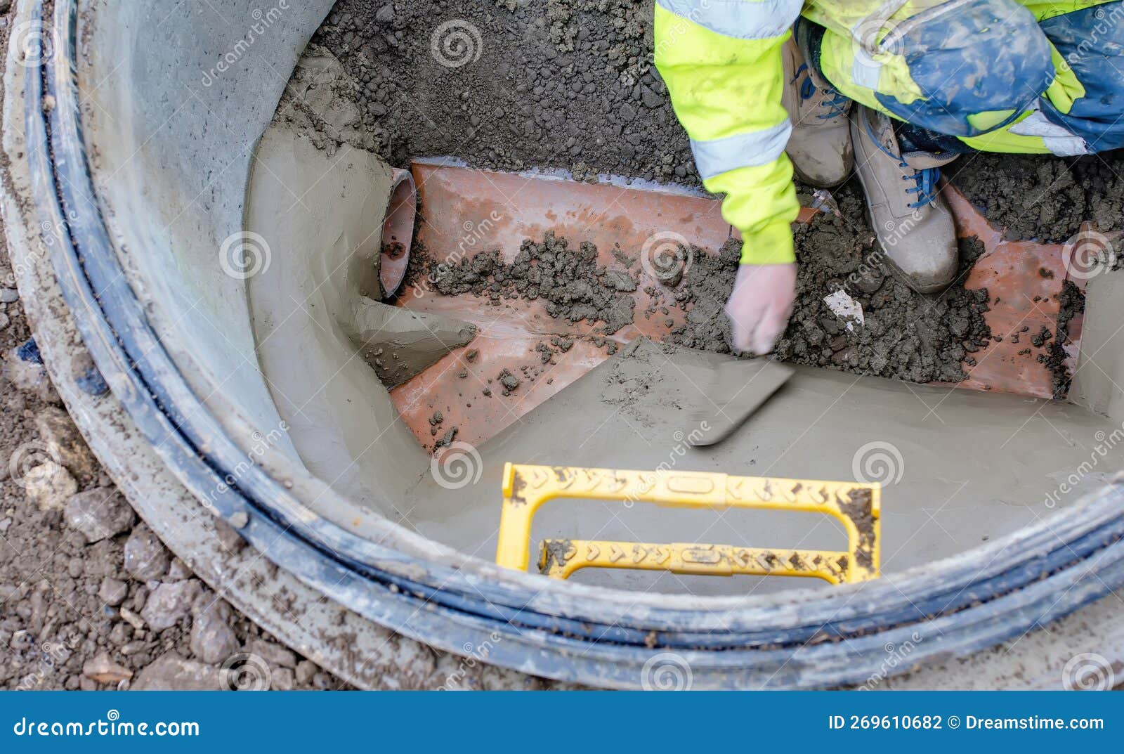 A Builder In The New Built Manhole Benching It With Sand And Cement Mix