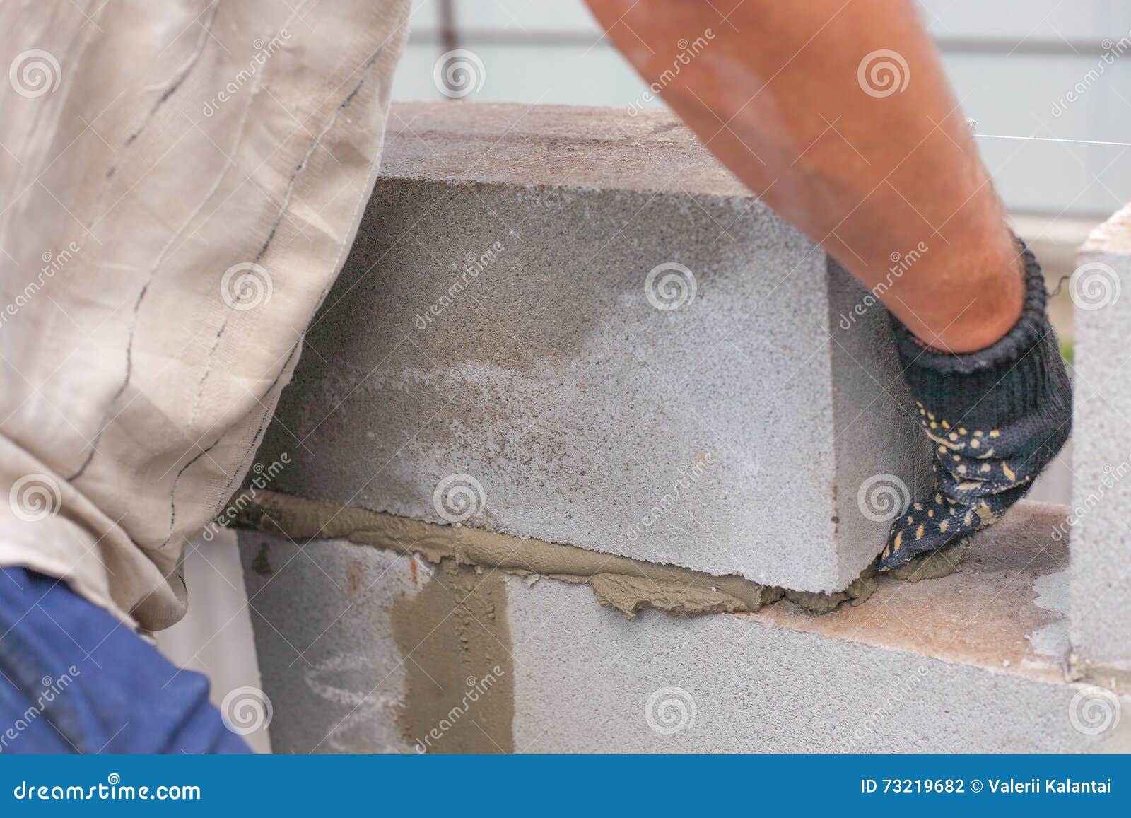 Builder Puts a Cinder Block for the Construction of the Building