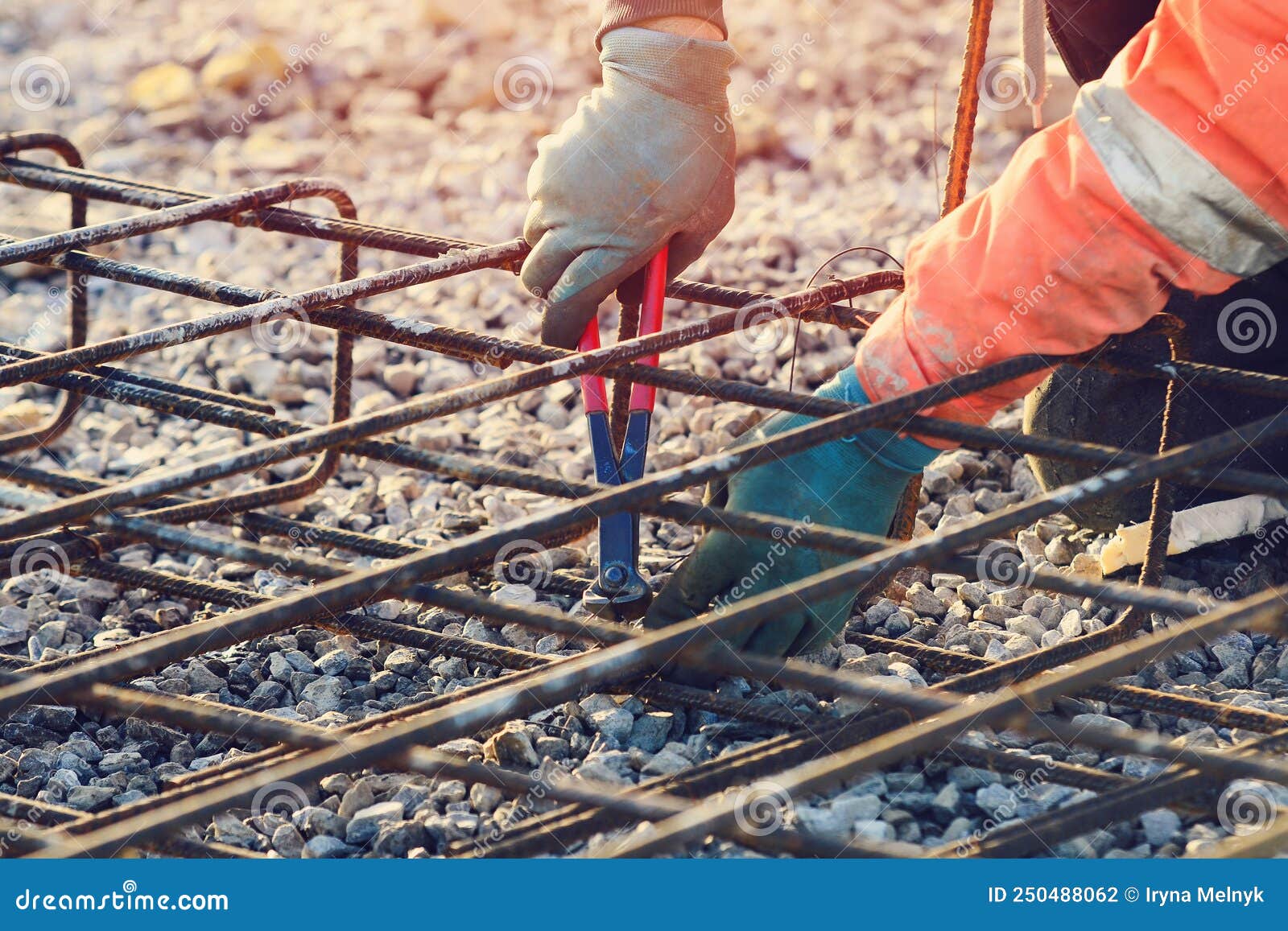 Builder`s Hands Fixing Steel Reinforcement Bars at Construction Site