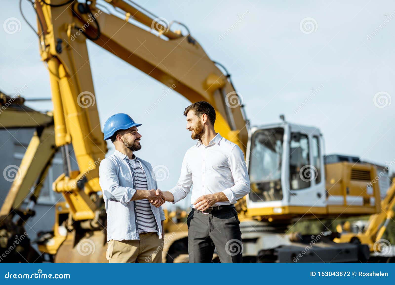 builder with a sales consultant at the shop with heavy machinery