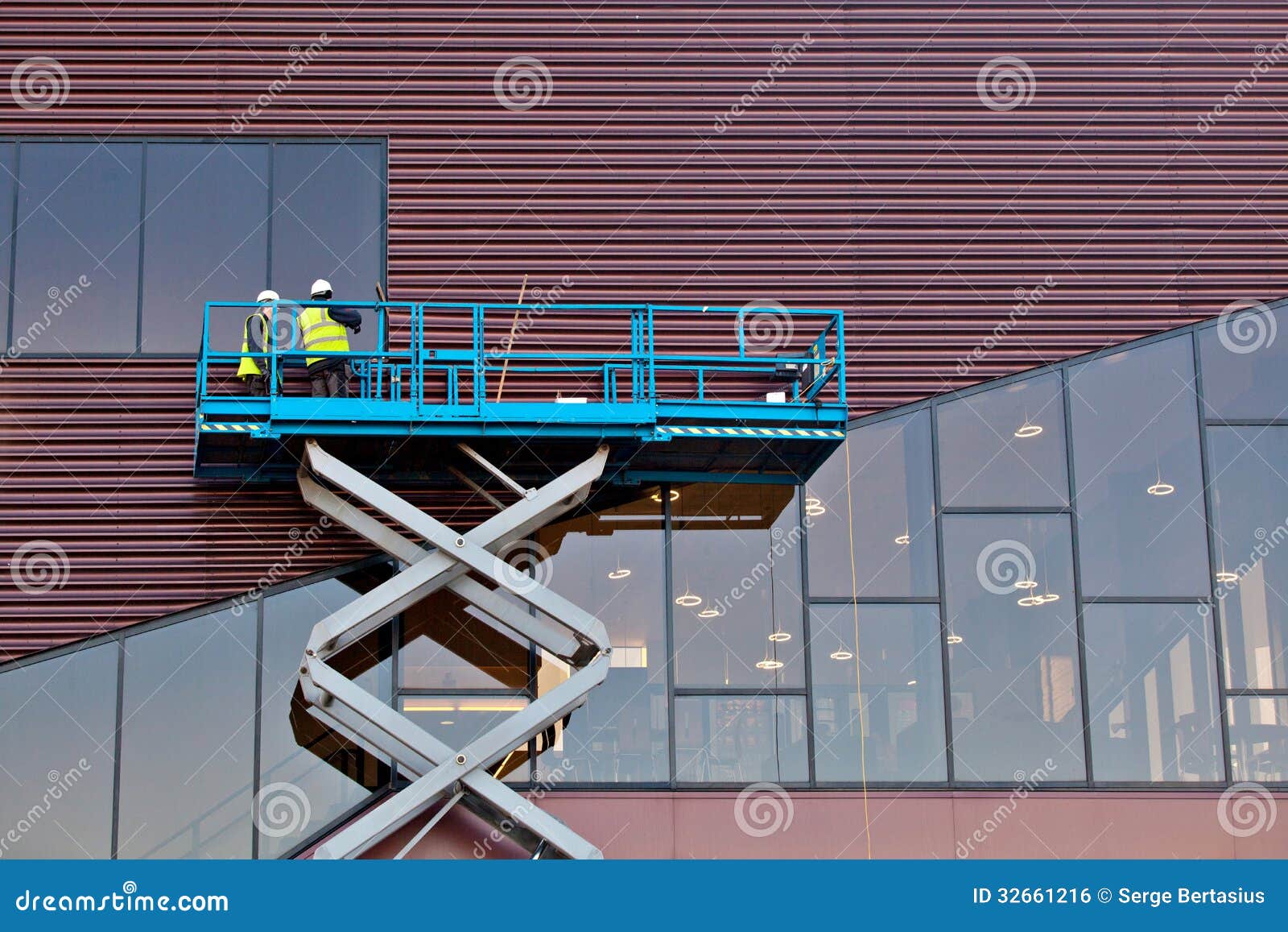 builder on a scissor lift platform at a construction site