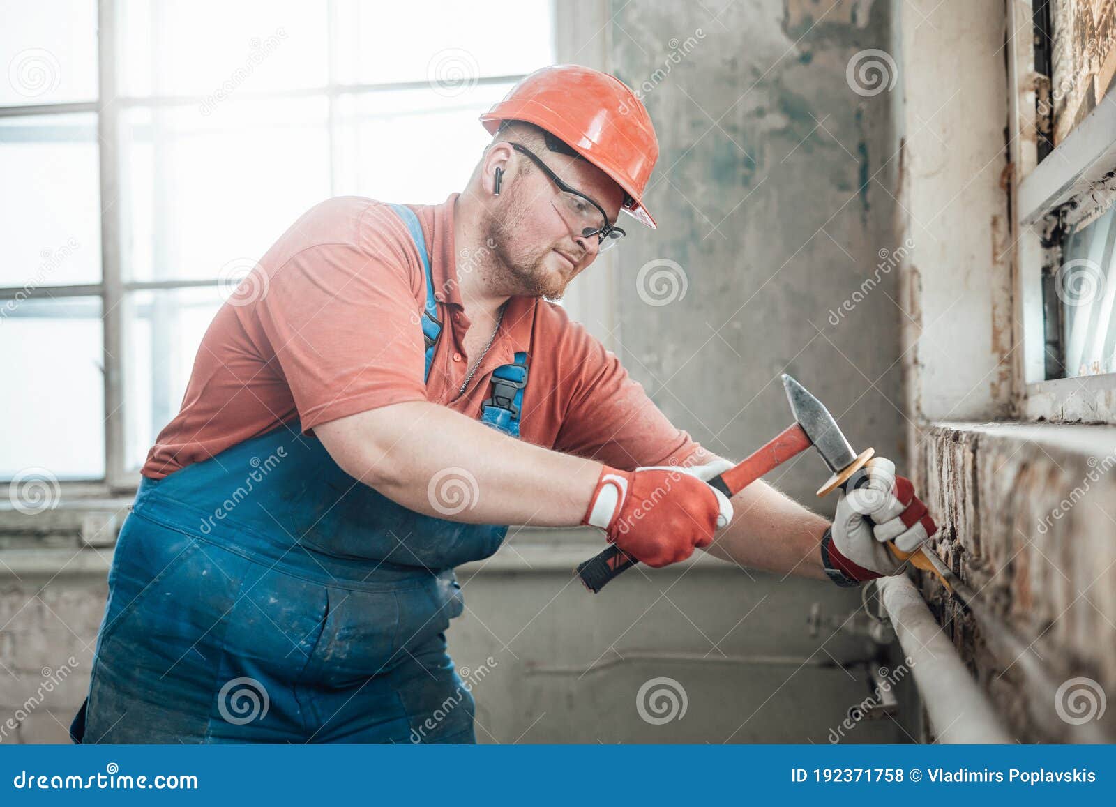 Builder in Th Uniform at a Construction Site Working on a Brick Wall