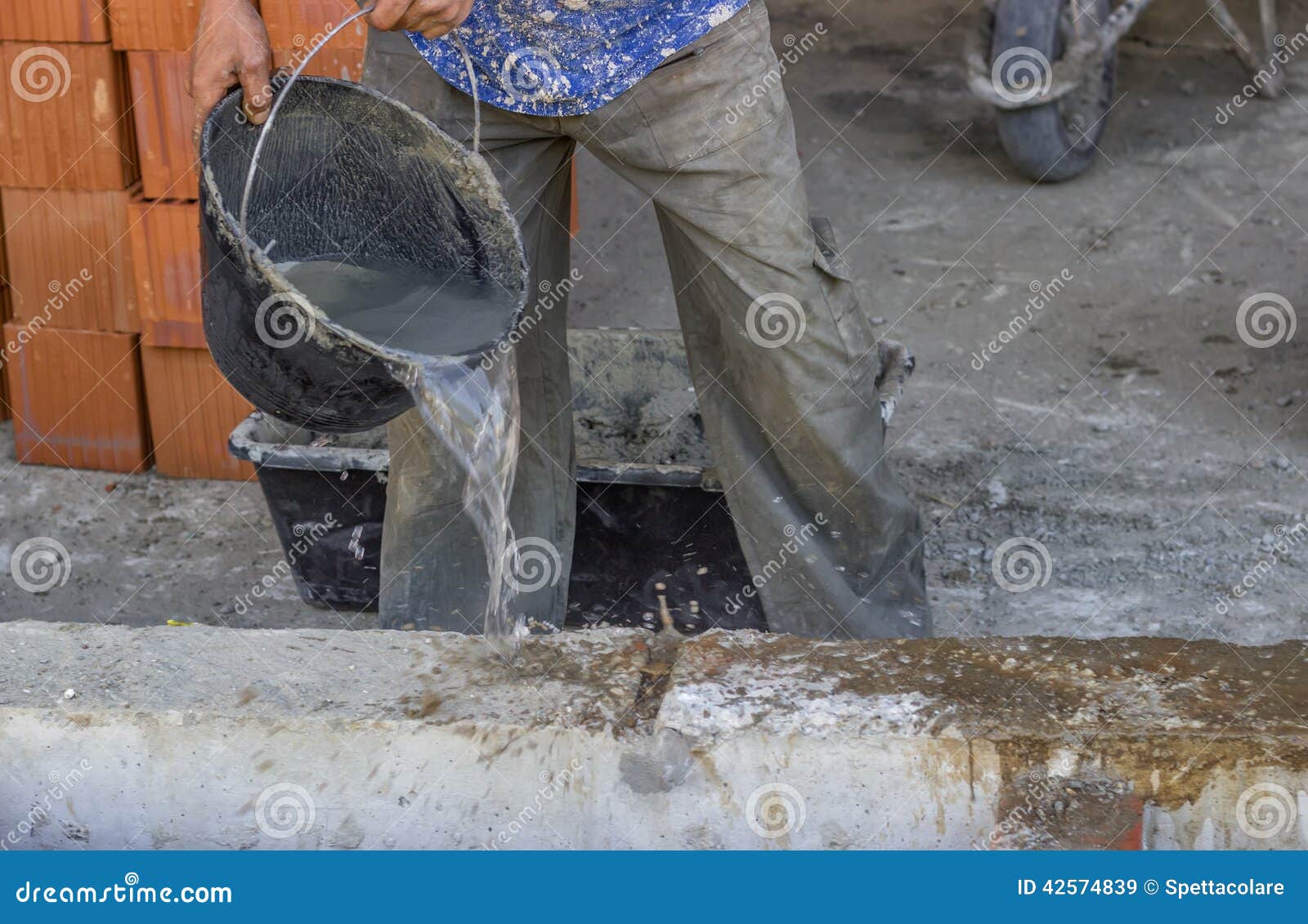 Builder Worker Wetting Concrete with Bucket of Water 2 Stock Image