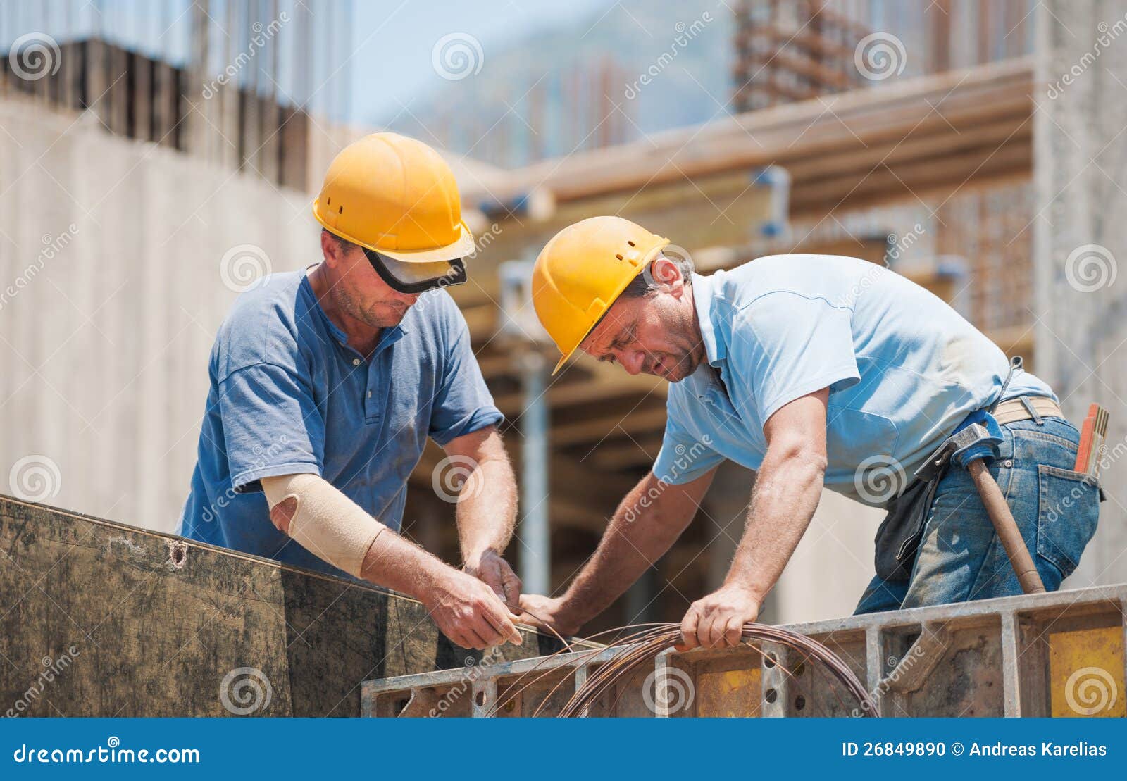 builders cooperating on cement formwork frames