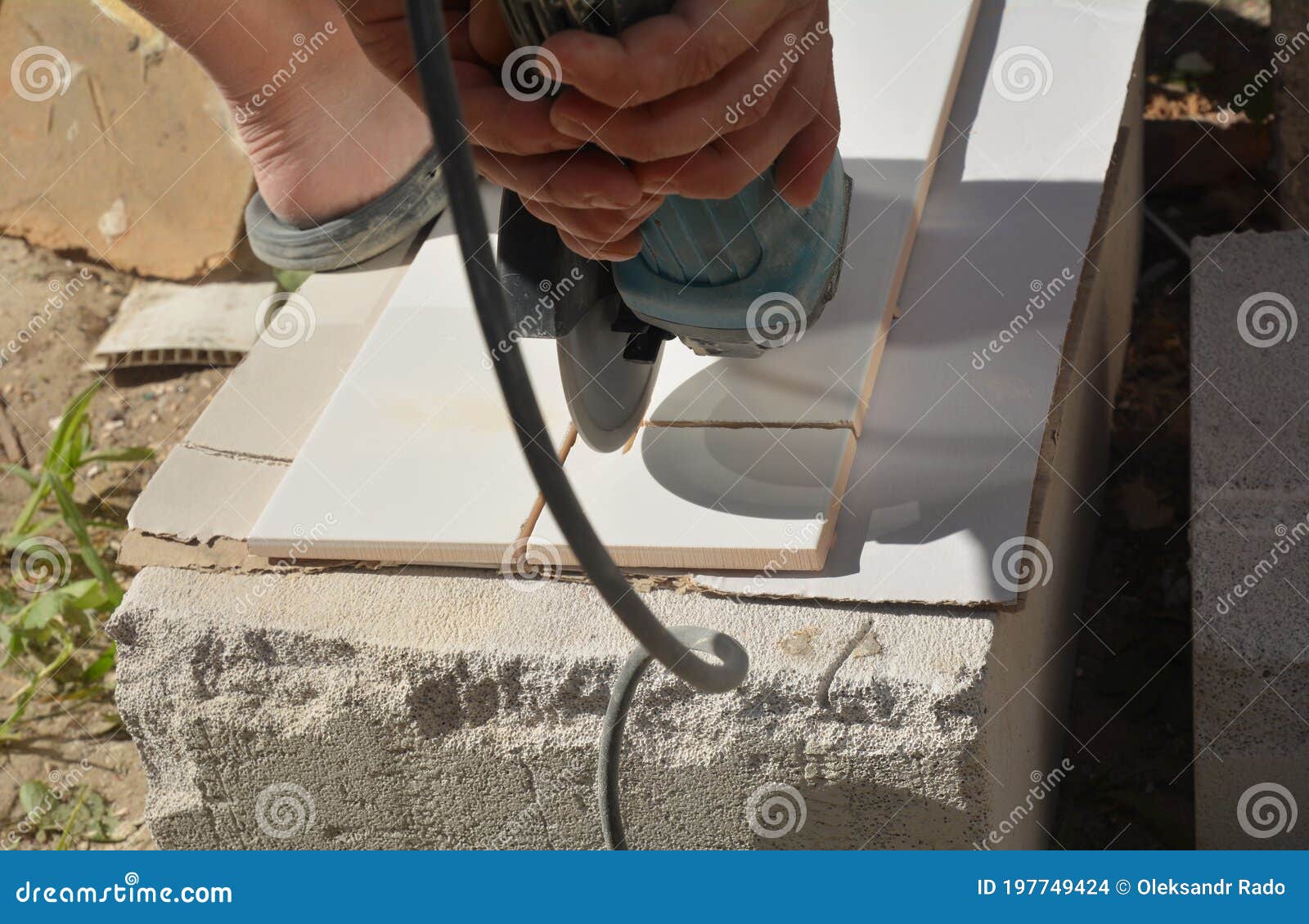 A Building Contractor is Cutting Ceramic Wall Tiles Using Electric Angle Disc Grinder Stock
