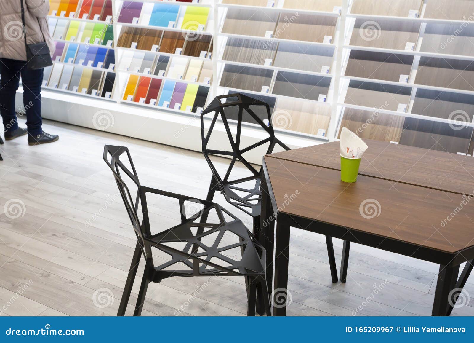 building shop with table and two chairs for clients and stands with samples at the background where you can choose color and textu