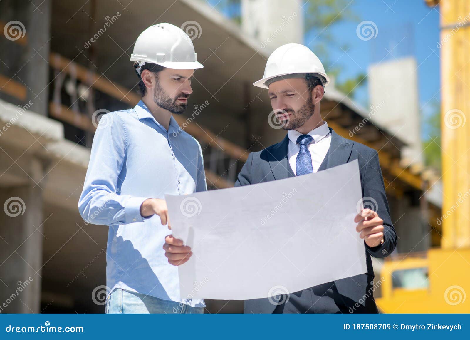 Building Supervisor Holding Blueprint, Discussing it with Foreman Stock