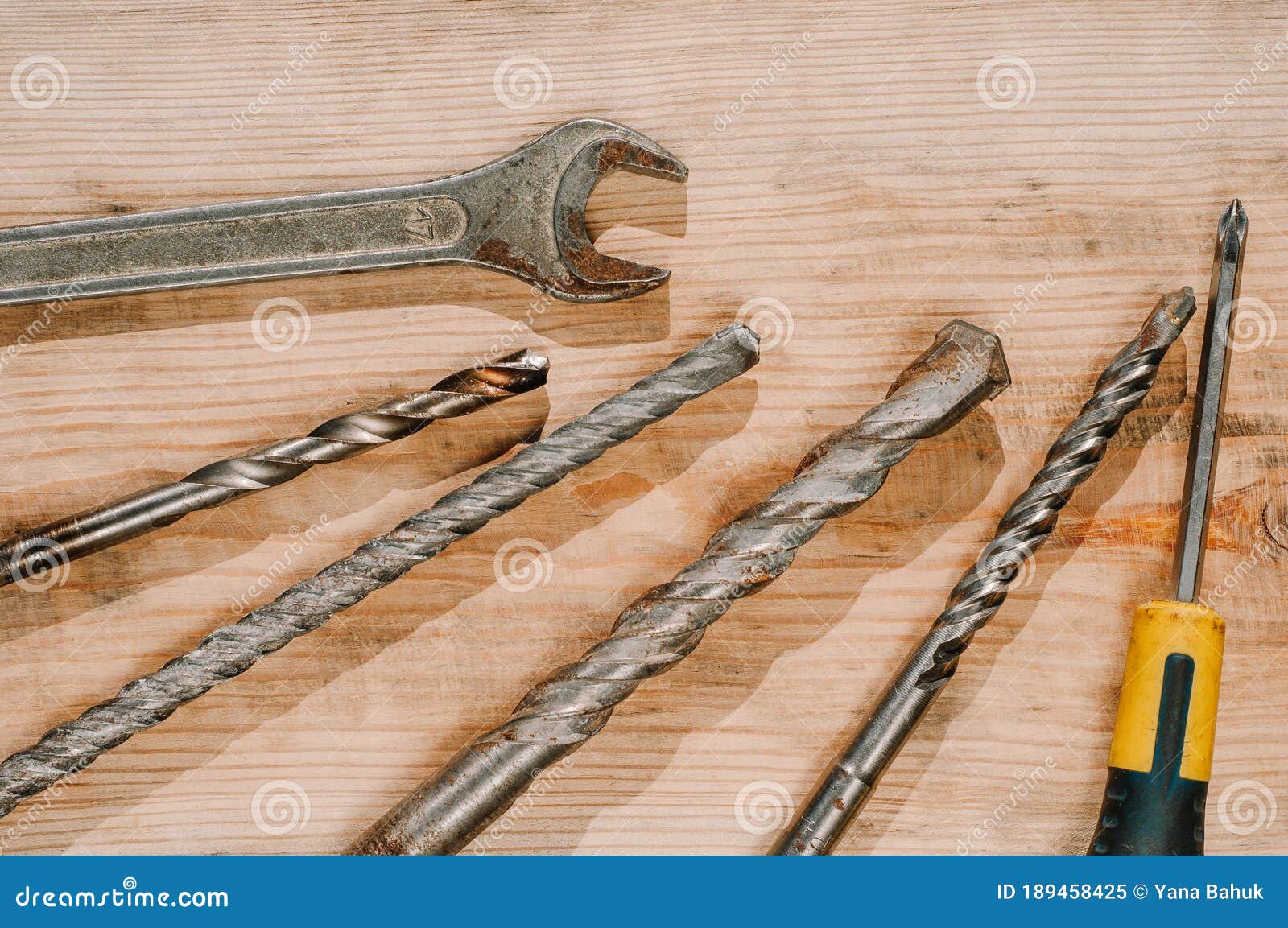 building tools including centimeter ruler, wrench and cutter placed in the right side on wooden surface with open space.