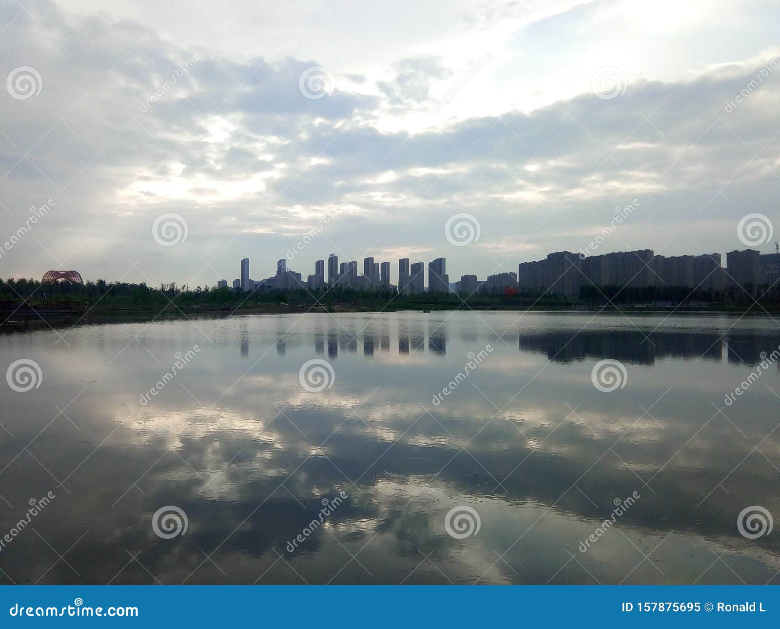 buildings and clouds reflected in calm lake in the city. reflection mirror