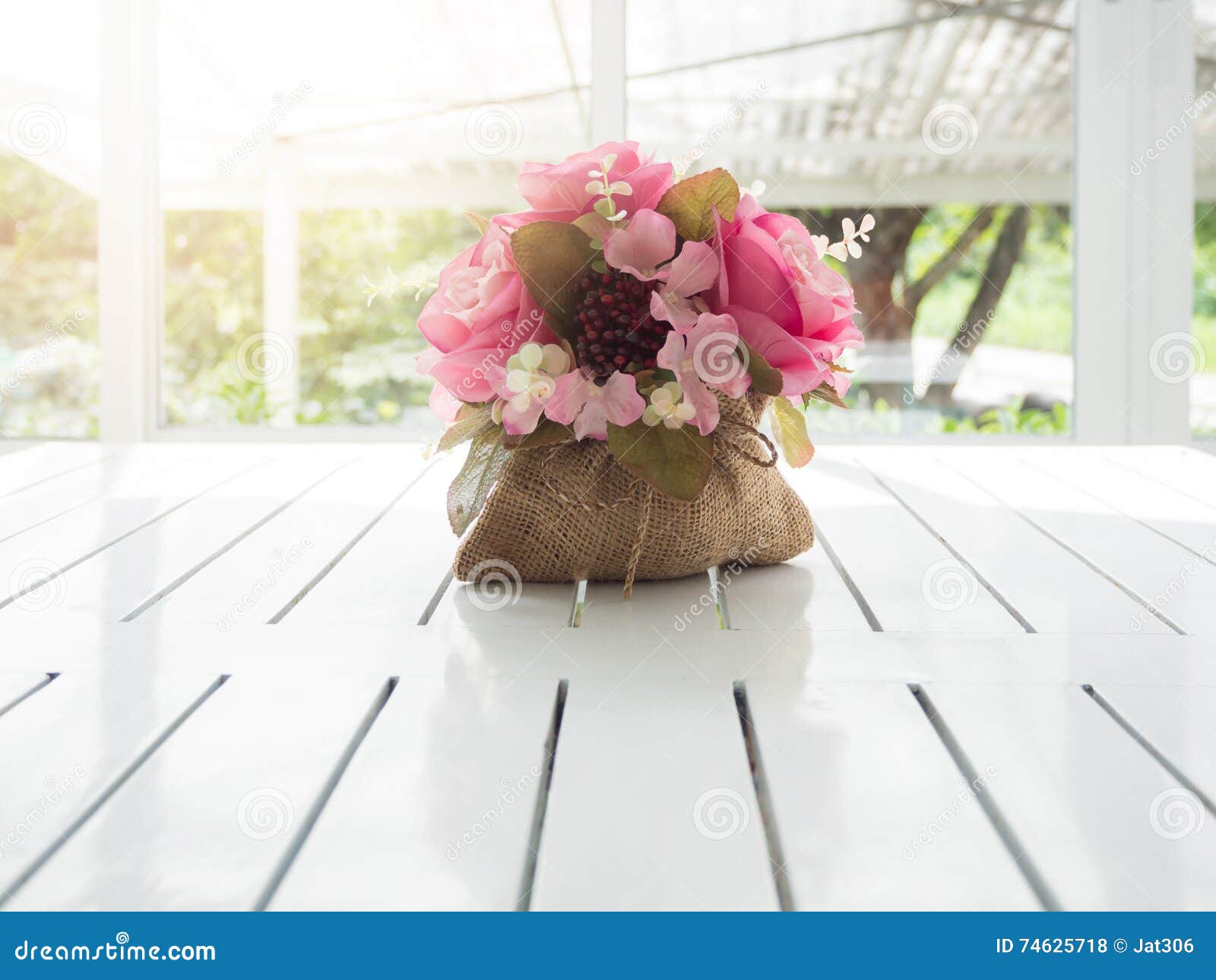 Bukiet piękni sztuczni kwiaty na białym drewnianym stole w sklep z kawą