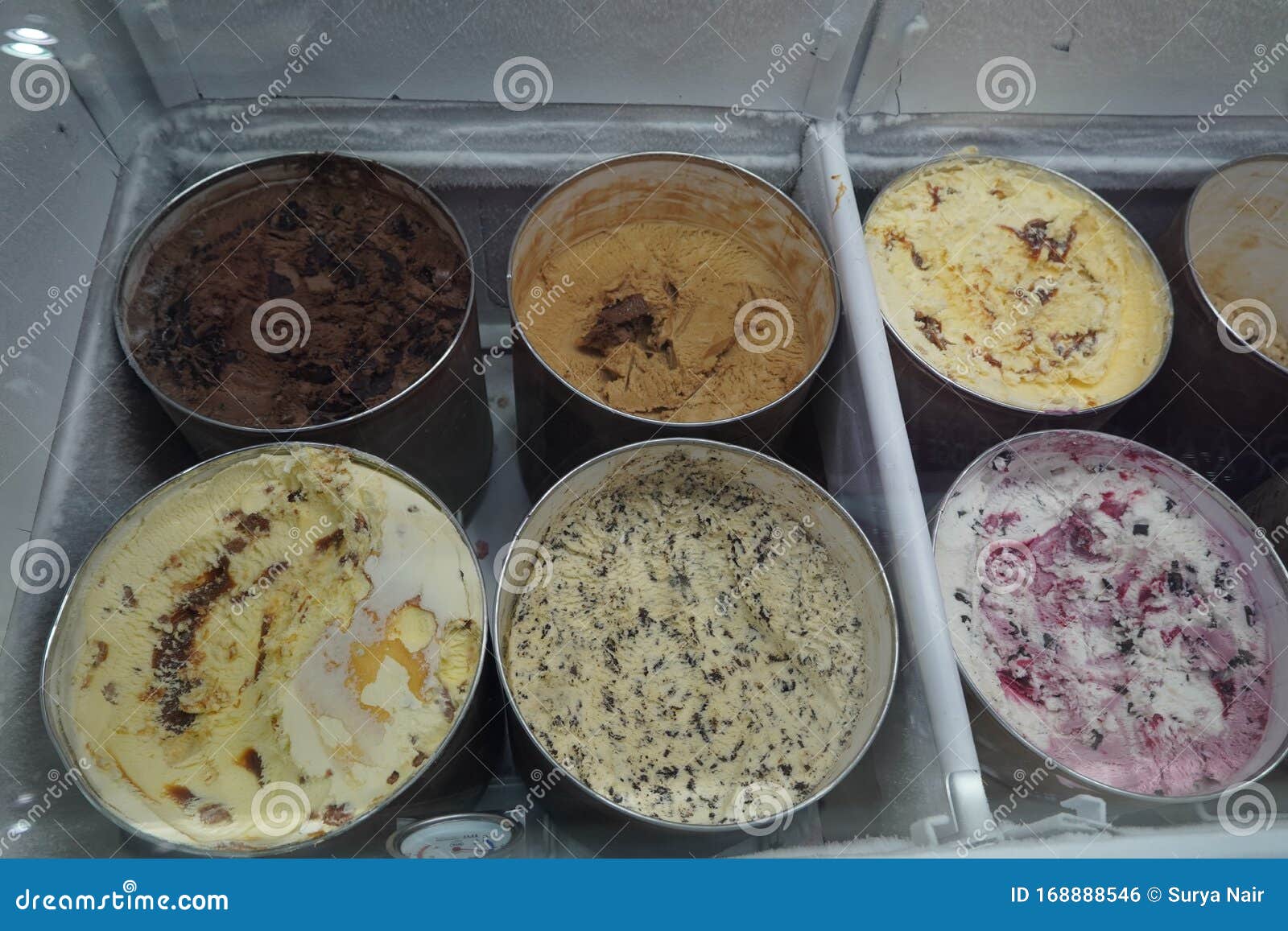 Bulk Ice Cream Kept in Large Round Containers Behind Glass at