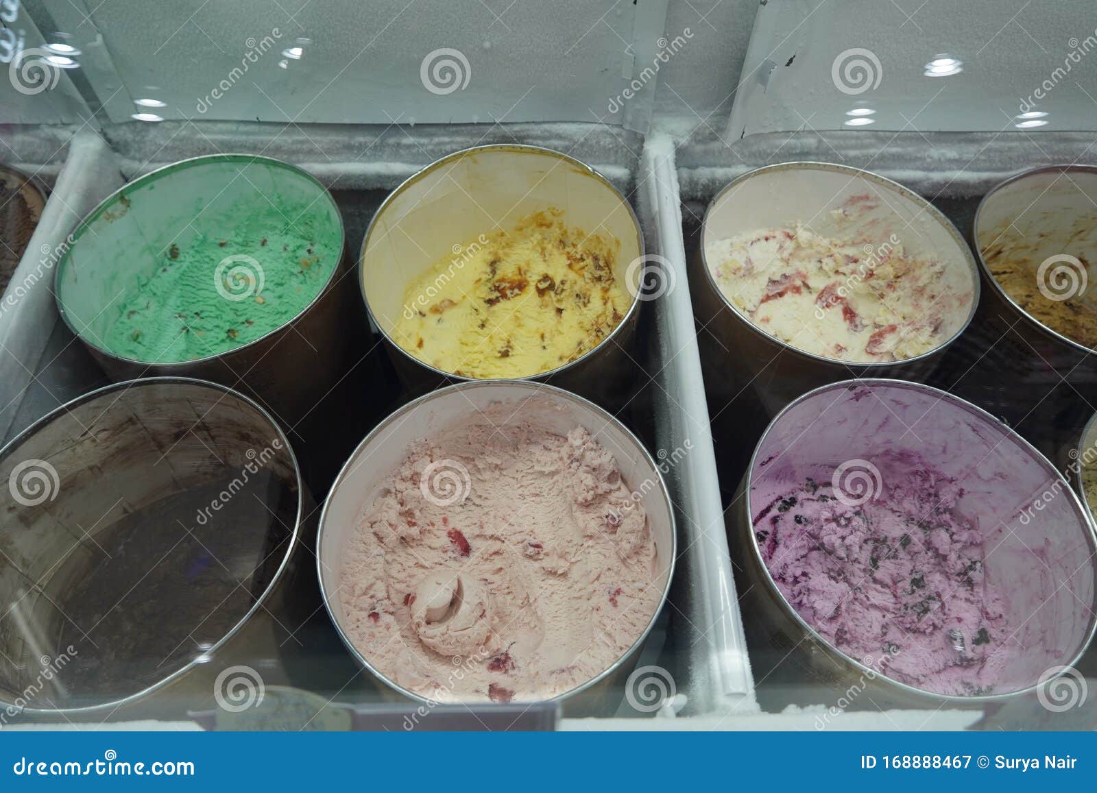 Bulk Ice Cream Kept in Large Round Containers Behind Glass at