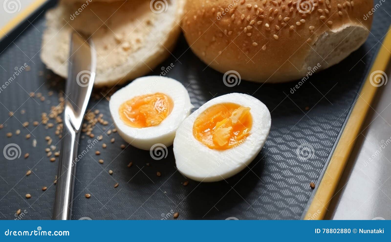 Bun with Sesame Seeds and Boiled Eggs on a Chopping Board Stock Photo