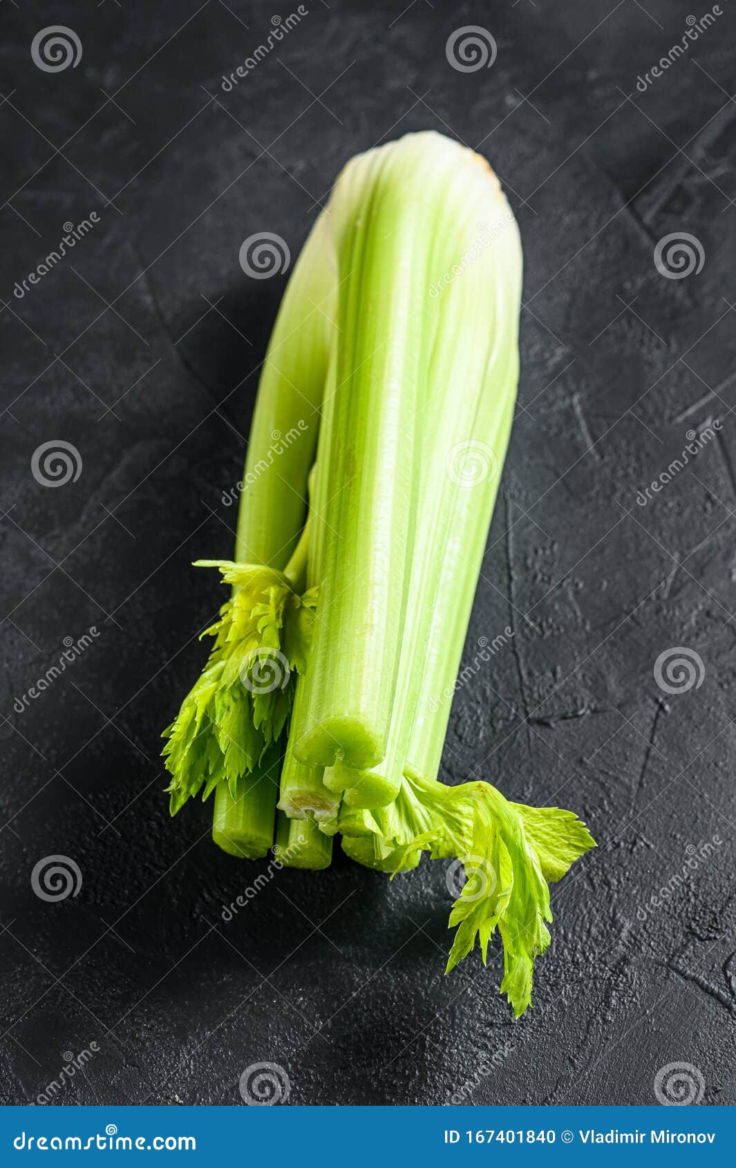 Bunch of Fresh Celery Stalk with Leaves. Black Background Stock Photo
