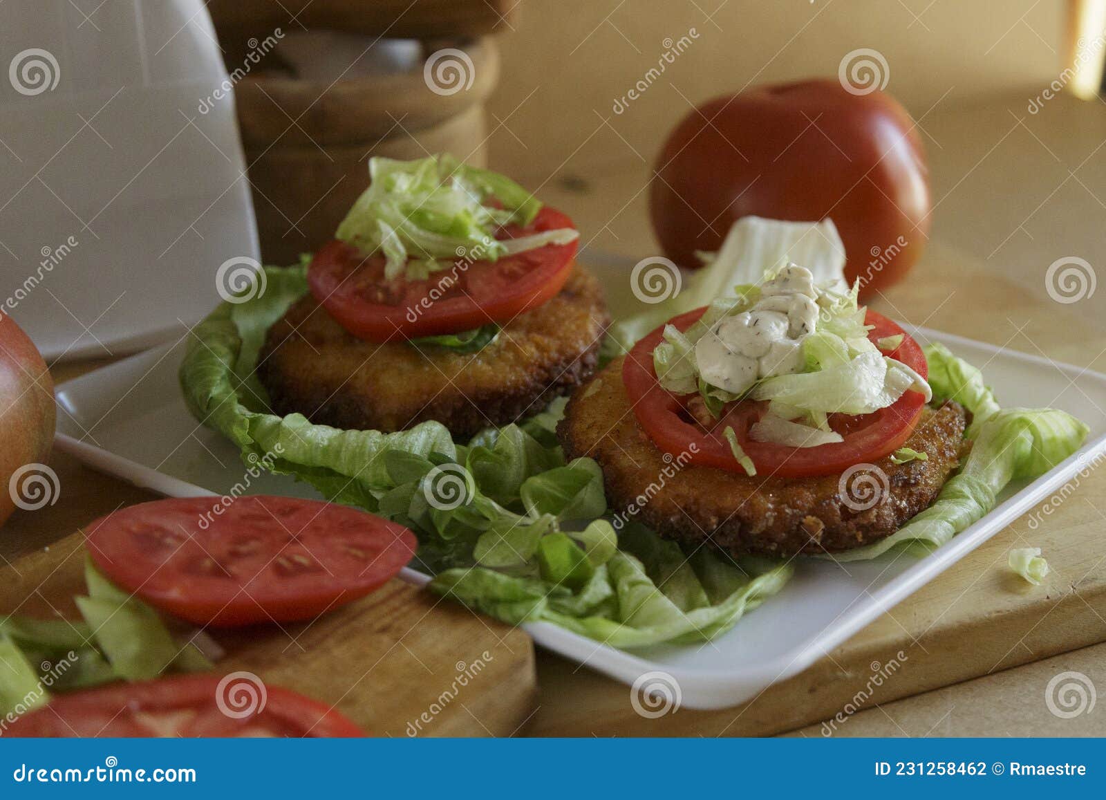 Burgers with Lettuce and Mayonnaise Served on Tomatoes Stock Photo