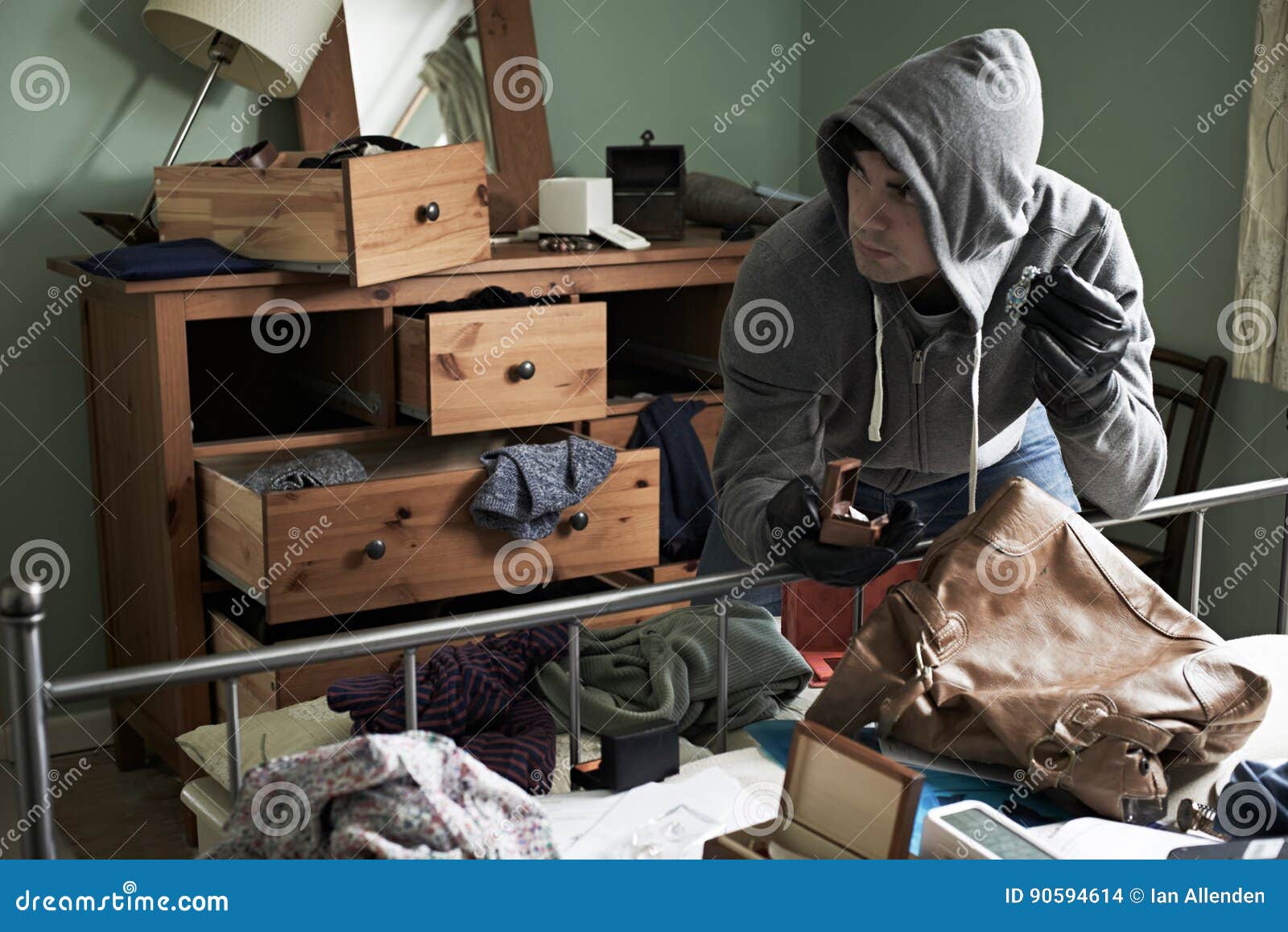 burglar stealing items from bedroom during house break in
