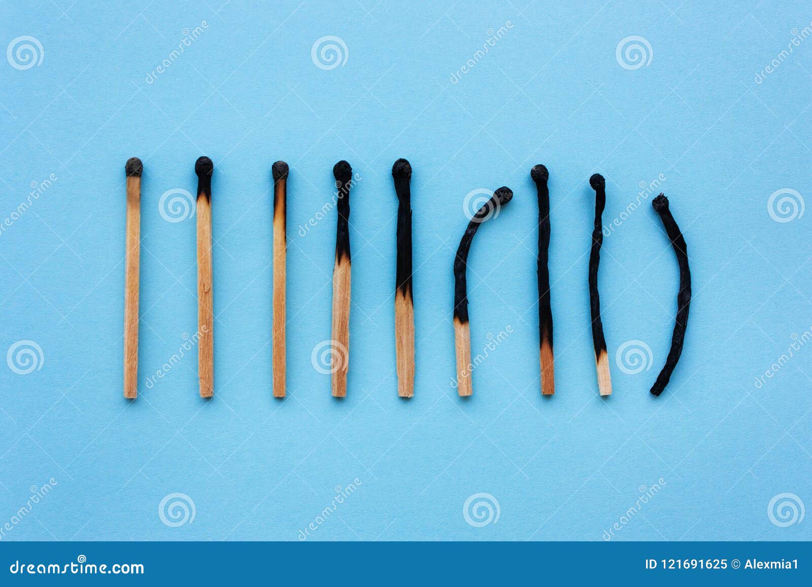 burned matches in a row on a blue background. the concept of depression, extinction, illness, burnout