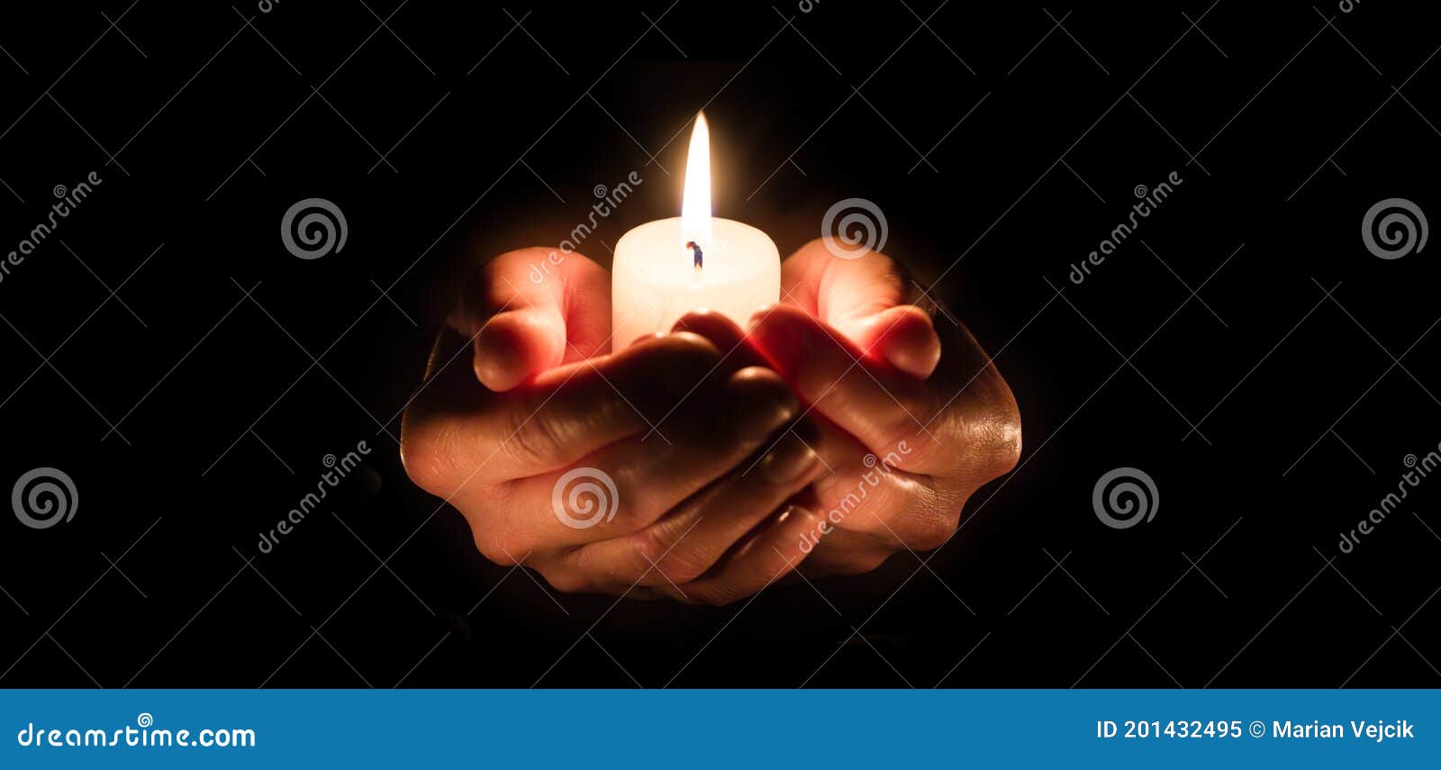 burning candle in woman hands over black. religious christmas spa and wellness concept