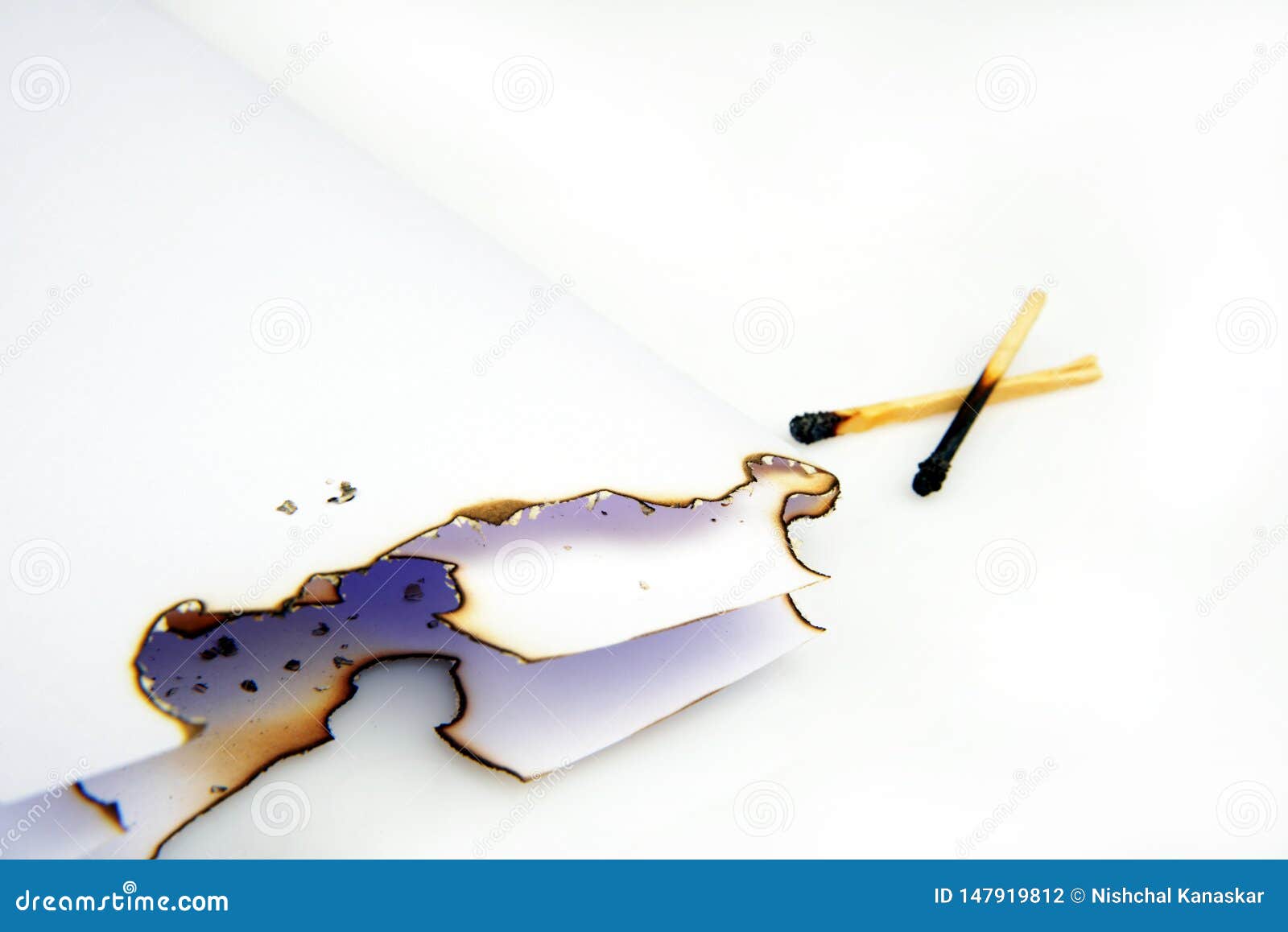 burnt paper document and match sticks on white background