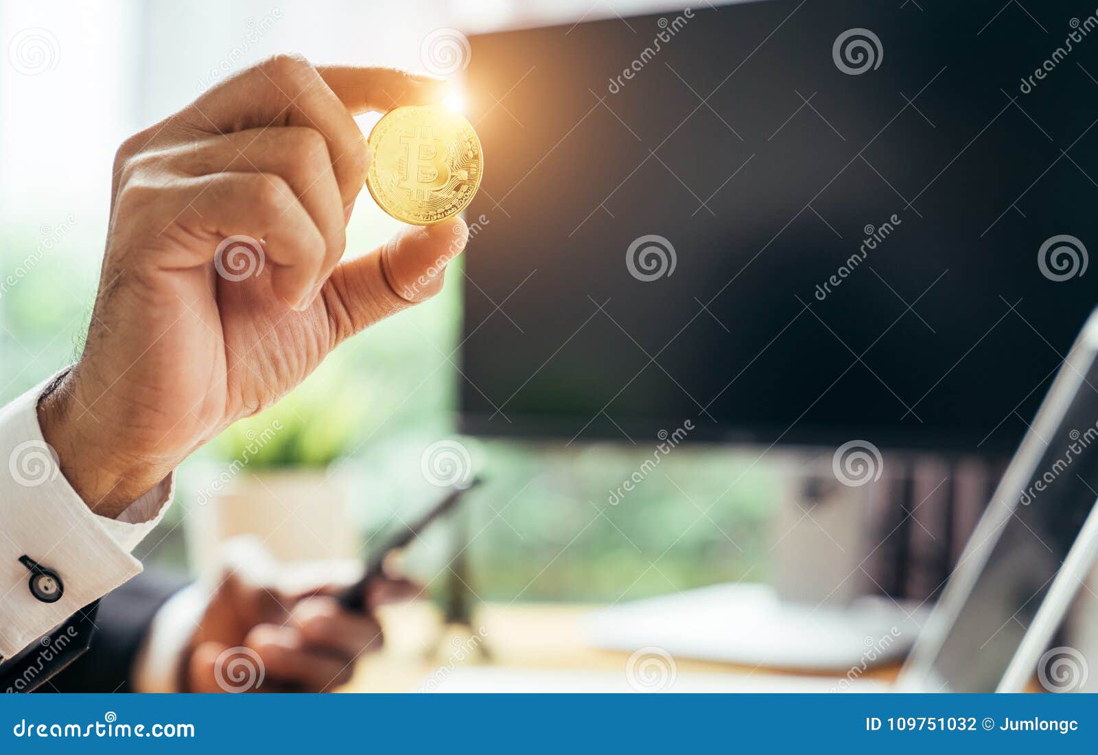 a busines man is holding a gold bitcoin