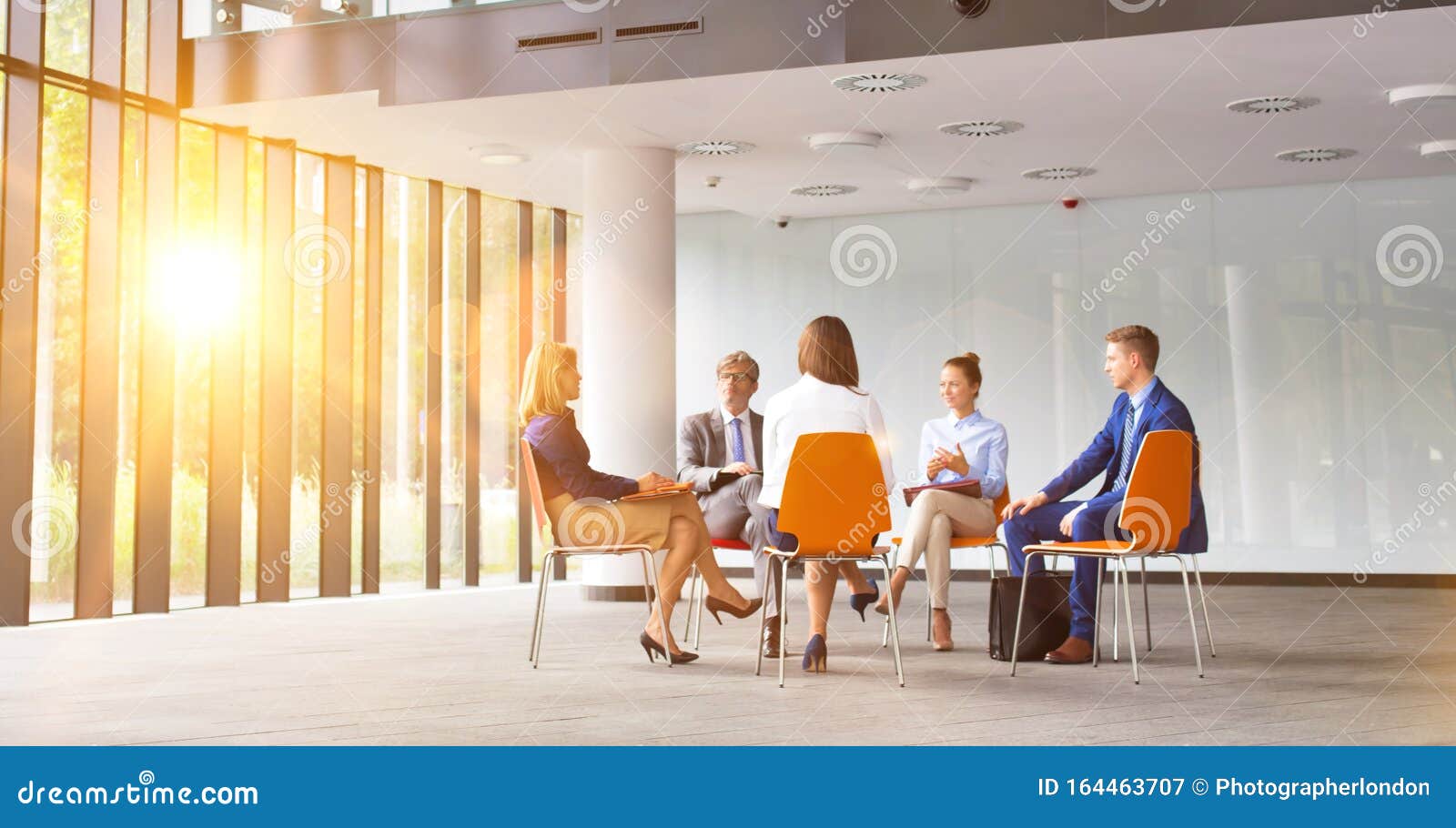 business colleagues planning strategy while sitting on chairs during meeting