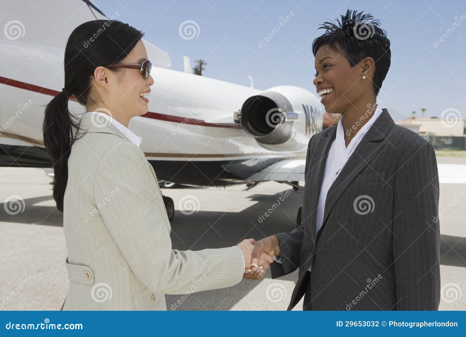 business colleagues shaking hands at airfield