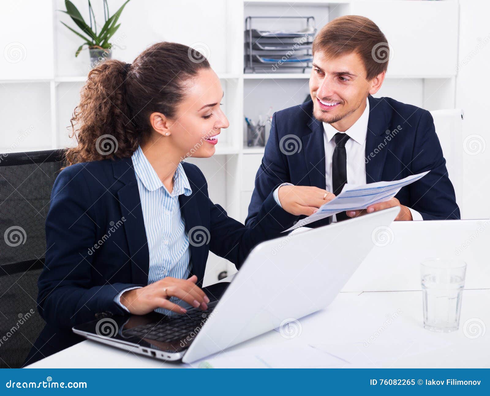 Business colleagues sitting with laptops. Portrait of positive adult business men and women colleagues sitting with laptops on desk in office