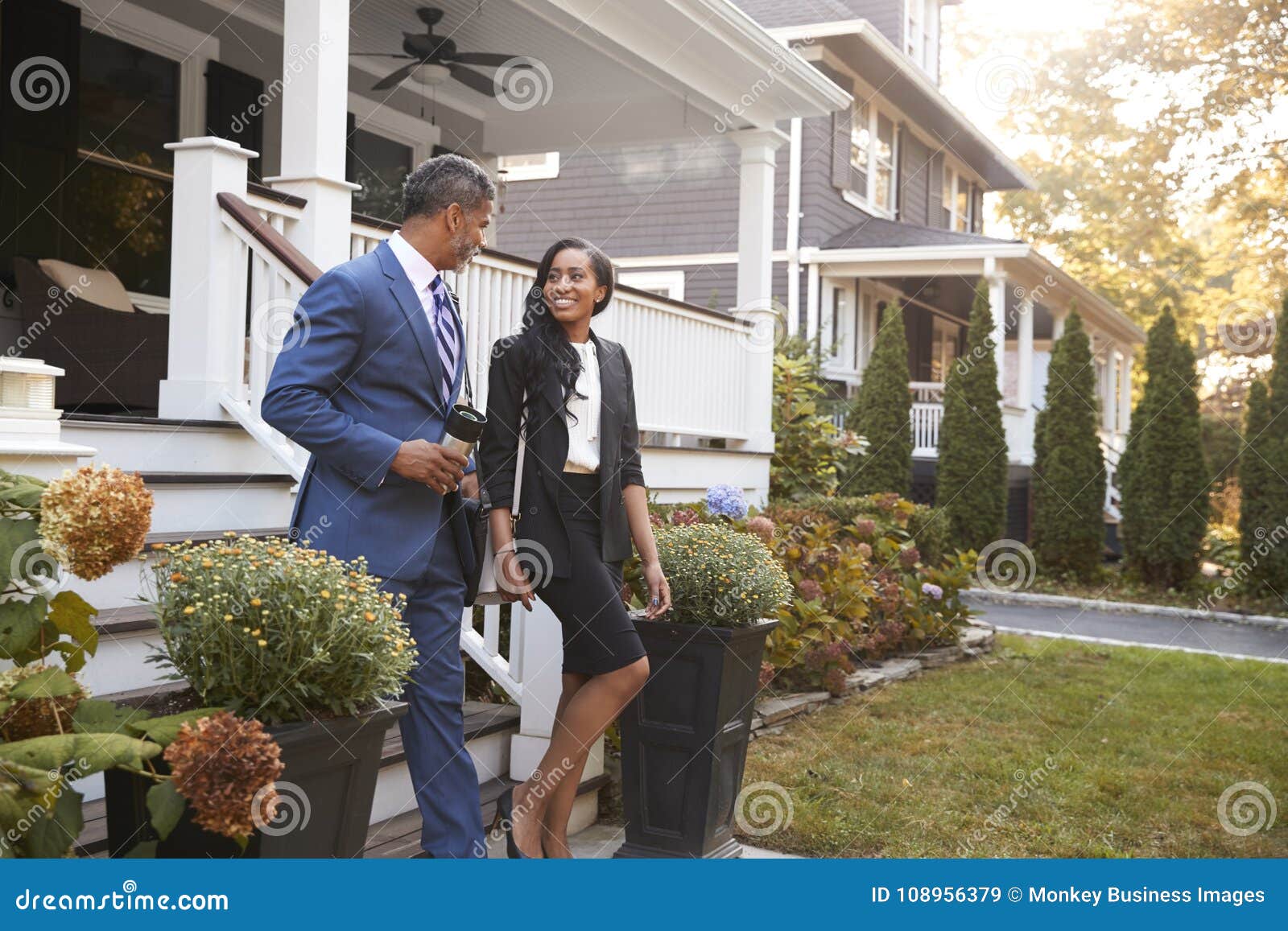 business couple leaving suburban house for commute to work