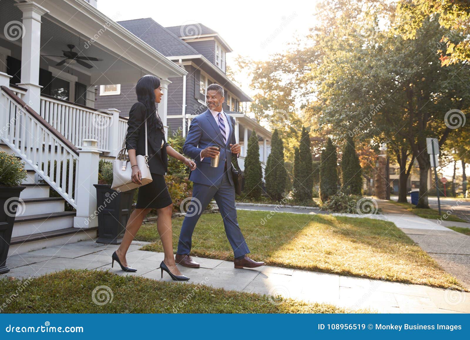 business couple leaving suburban house for commute to work