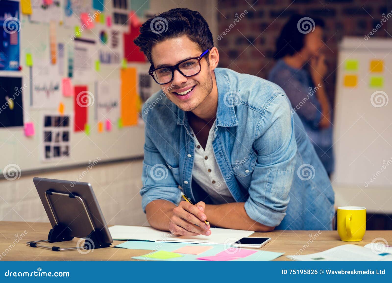 Business Executive Using Digital Tablet and Taking Notes in Diary Stock