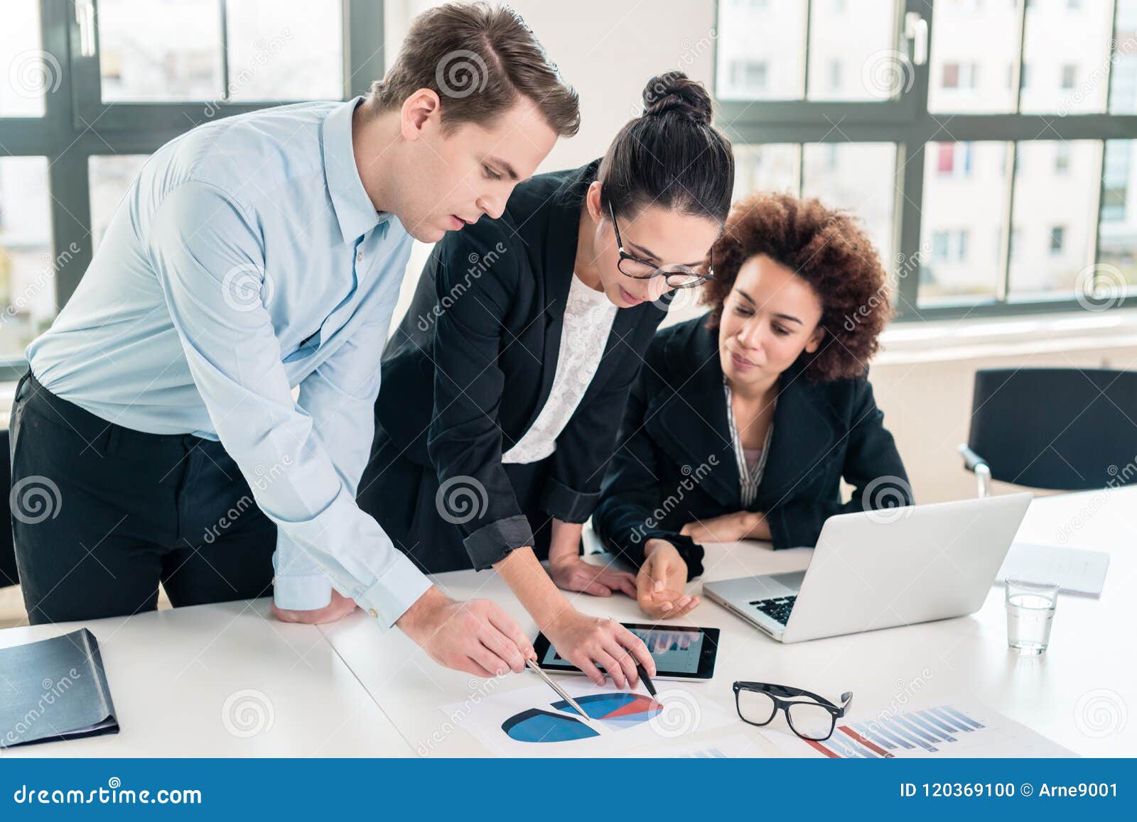 business experts interpreting pie chart printed on paper