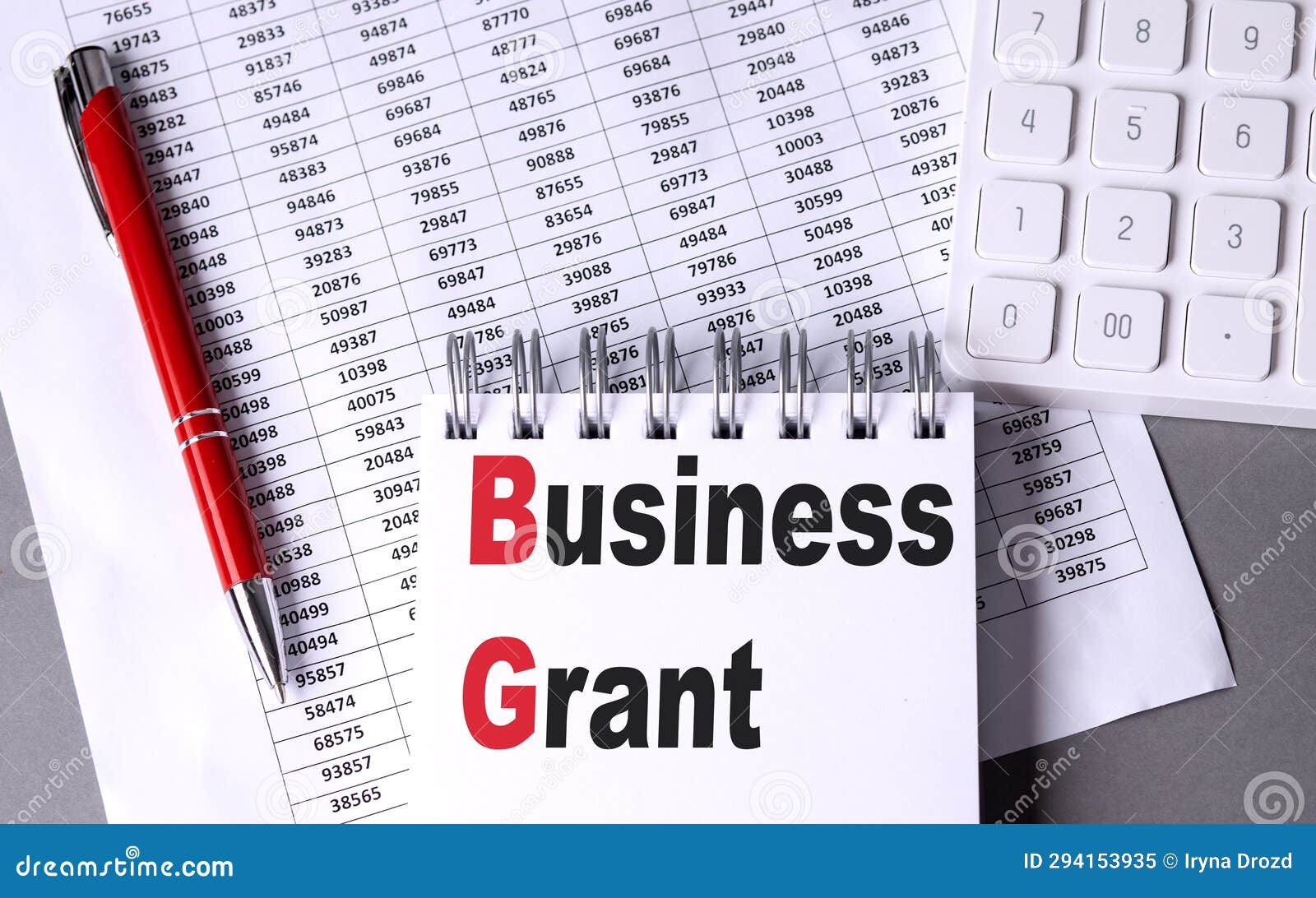BUSINESS GRANT Text on Notebook with Pen, Calculator and Chart on Grey