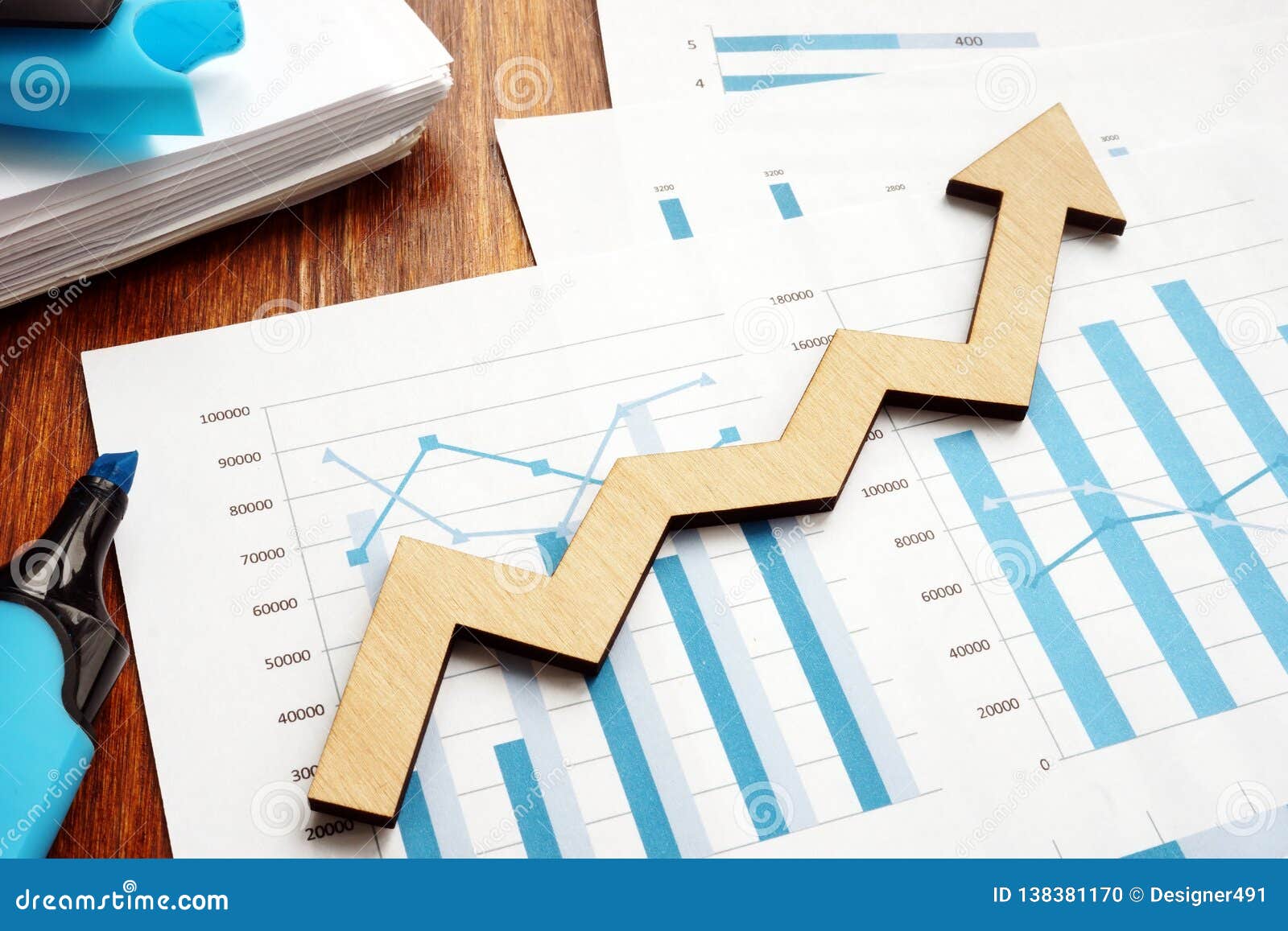 business growth. wooden arrow and financial reports