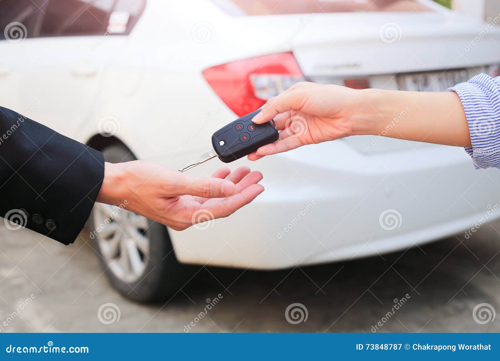business hand giving a key for buyer or rental car.